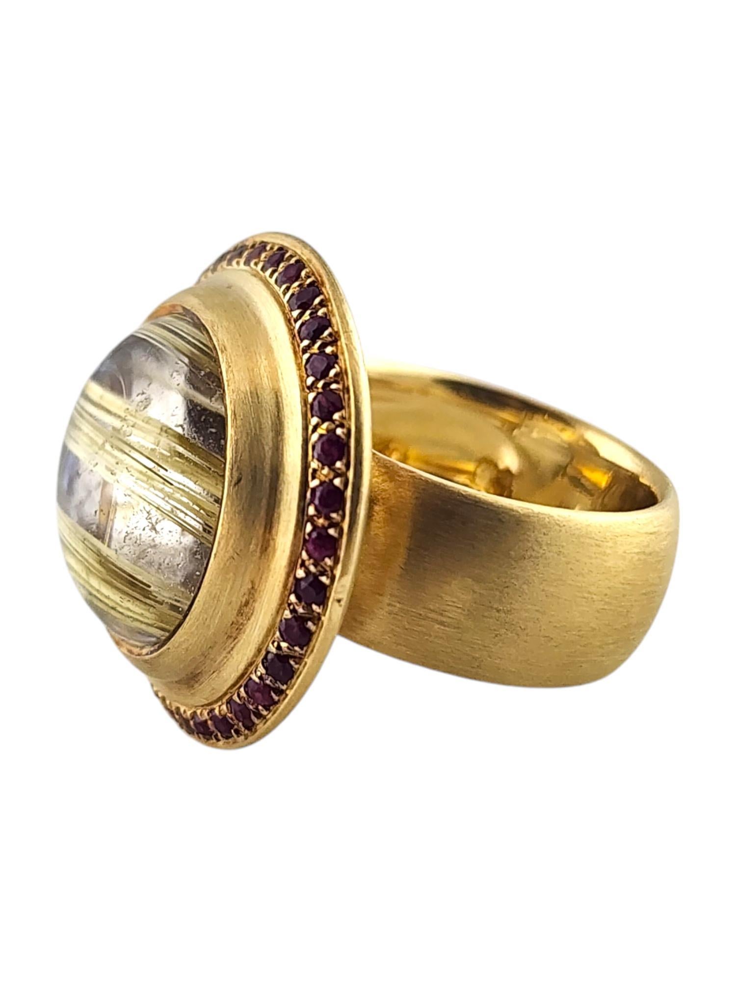 Bague en or jaune 18 carats rutilés et rubis naturels en forme de halo Taille 7

Cette magnifique bague est composée d'un quartz rutile rond taillé en cabochon et d'un halo de rubis naturel composé de 36 rubis ronds taillés, le tout serti dans de