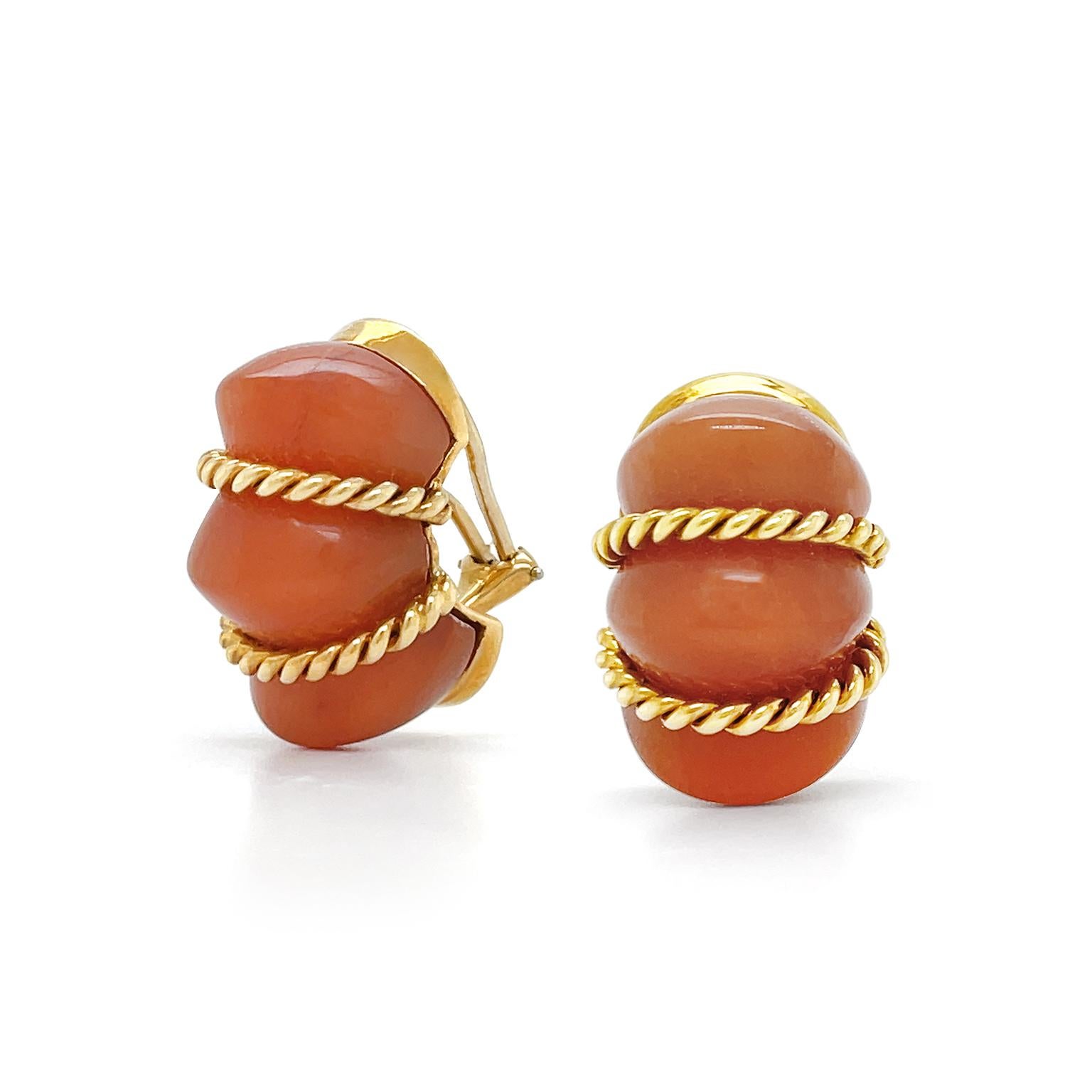 The treasured translucency of pink aventurine is the focus of these earrings. Carved into a trio of raised mounds, the design resembles a shrimp. 18k yellow gold braids rest in the dips of the carving to bring out the color of the aventurine. When