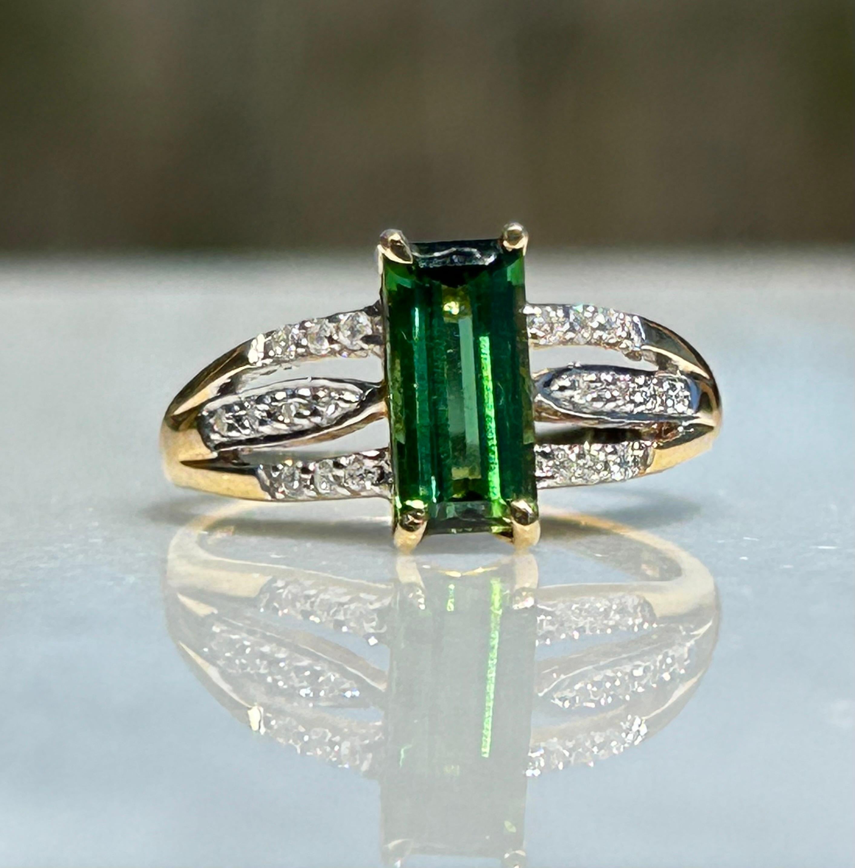 A 18K Yellow Gold Santa Rosa Tourmaline and Diamond ring, the head set with a claw mounted Emerald cut tourmaline and  three rows of diamonds to either shoulder, ring size 6.75 weight 3.6 grams
This exquisite ring features a captivating, super
