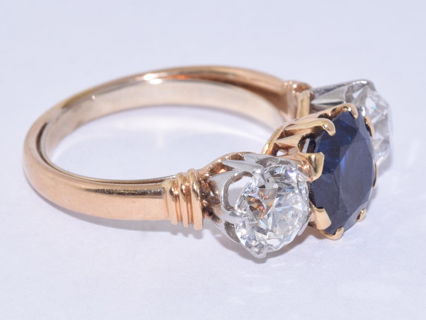 18K Yellow Gold Sapphire and Diamond 3 Stone Ring by American designer Spaulding & Co., circa 1890s .  One Cushion cut sapphire weighs approximately 2.50 carats.  Two Old European cut diamonds weigh approximately 2 carats in total.  Ring currently