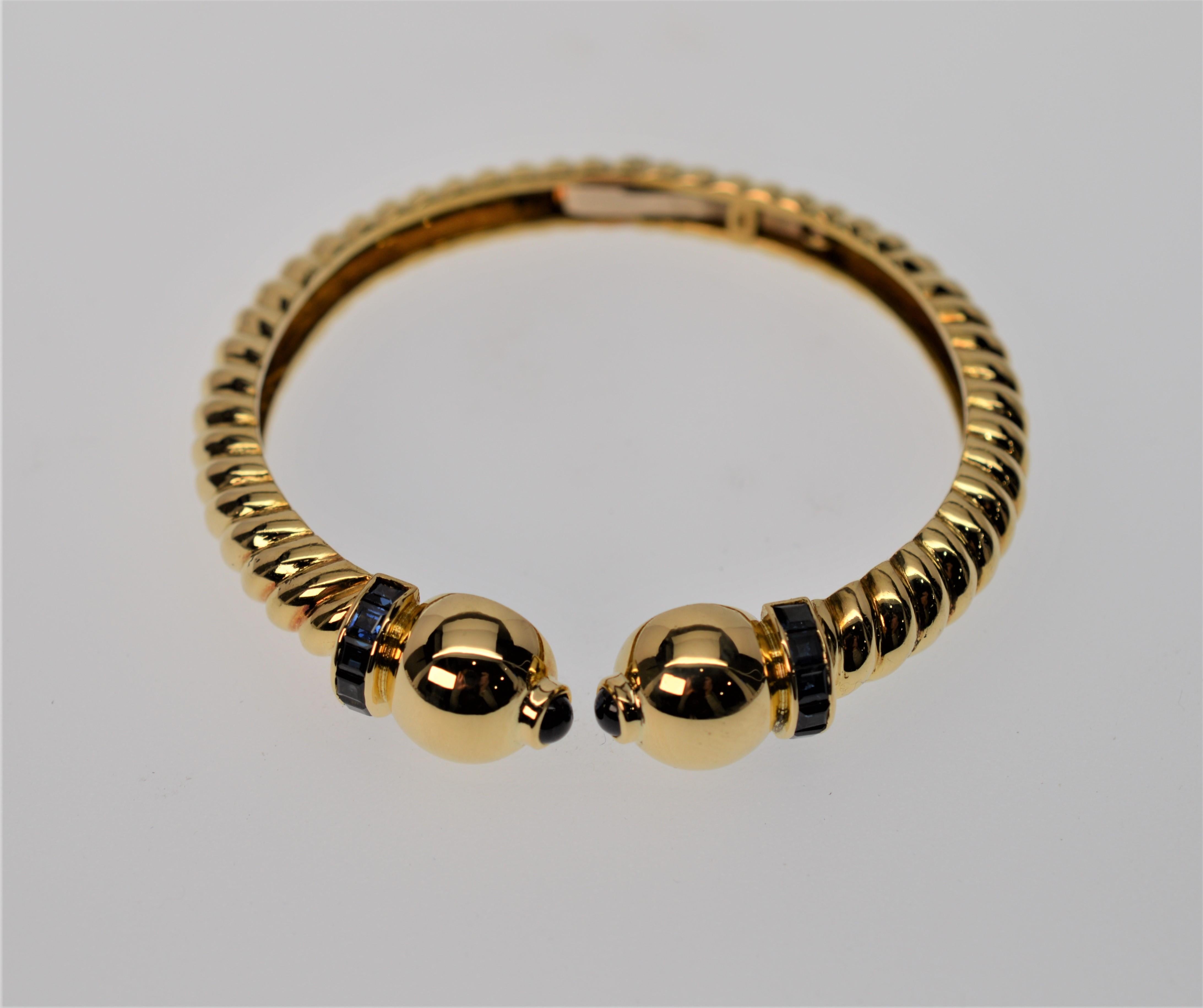 European, circa post war late 1940s, 18K Yellow Gold Cuff Bracelet with twist rope style finished with ball cap design adorned with Blue Sapphire. 
Measures 2-1/4 inches with .32 cts Blue Sapphire and 24.0 pennyweight of .750 Gold. In unusually fine