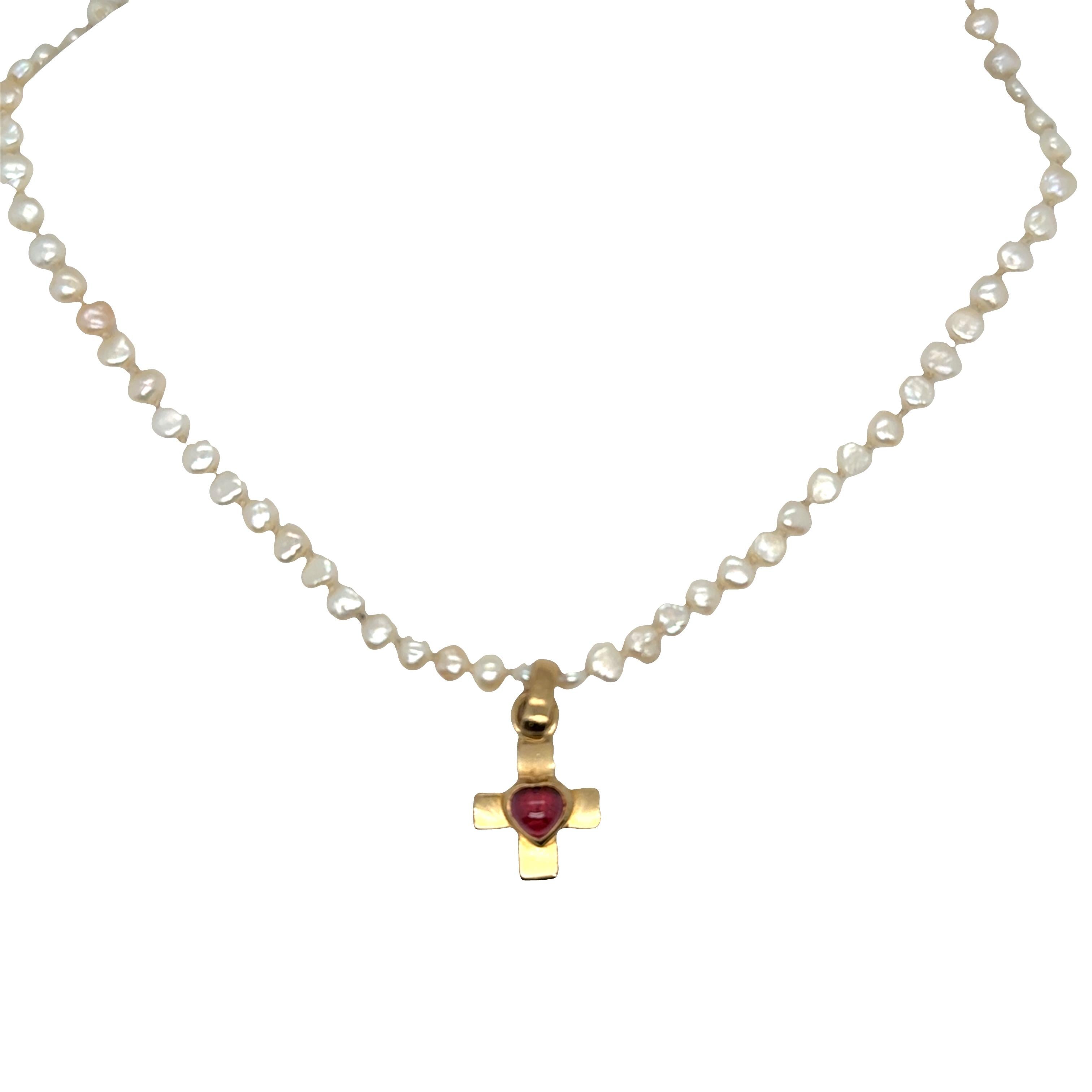Una delicada mezcla de fe, elegancia y refinada artesanía.
Este collar de perlas de siembra ecológicas tiene perlas naturales suaves de 3 a 5 mm de ancho, cada una con una forma y un brillo únicos. En su centro cuelga un colgante en forma de cruz