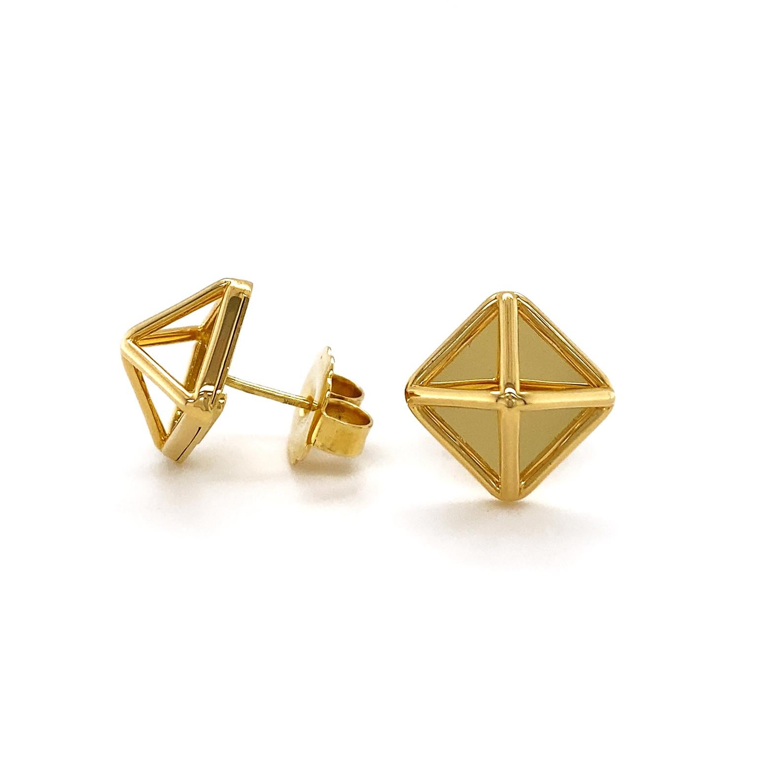 The flicker of gold is showcased in these geometric earrings. A high polished rhombus forms the base framed by slender gold bars. Extending from each corner are four bars forming a raised pyramid motif, which also shine against the highly reflective