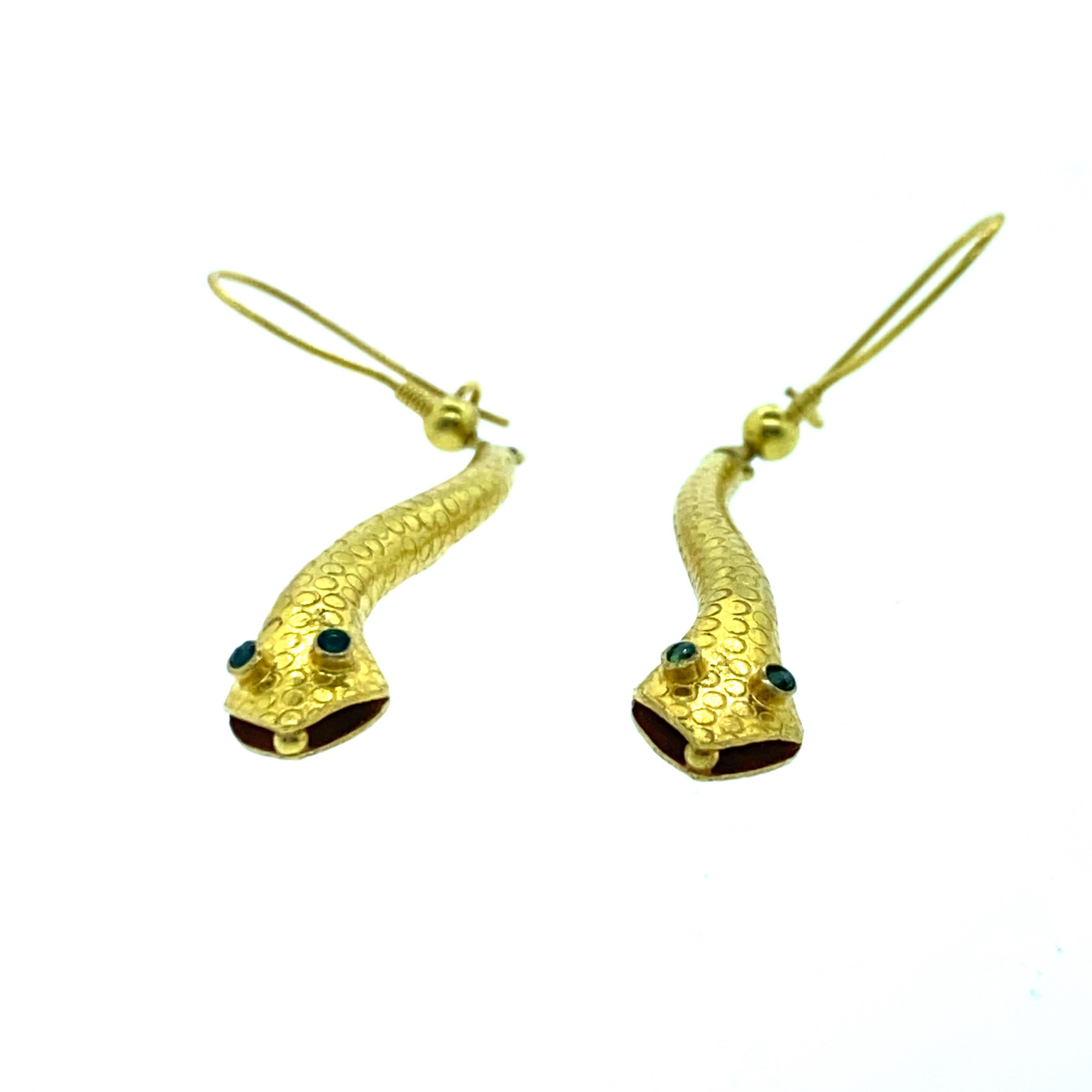 18K Yellow Gold Snake Earring with Emerald Eyes.The snake earring is finely crafted and handmade in India. The snake earring has intricate details to it. The mouth of the snake and the body of the snake have been beautifully made. The ear wire also