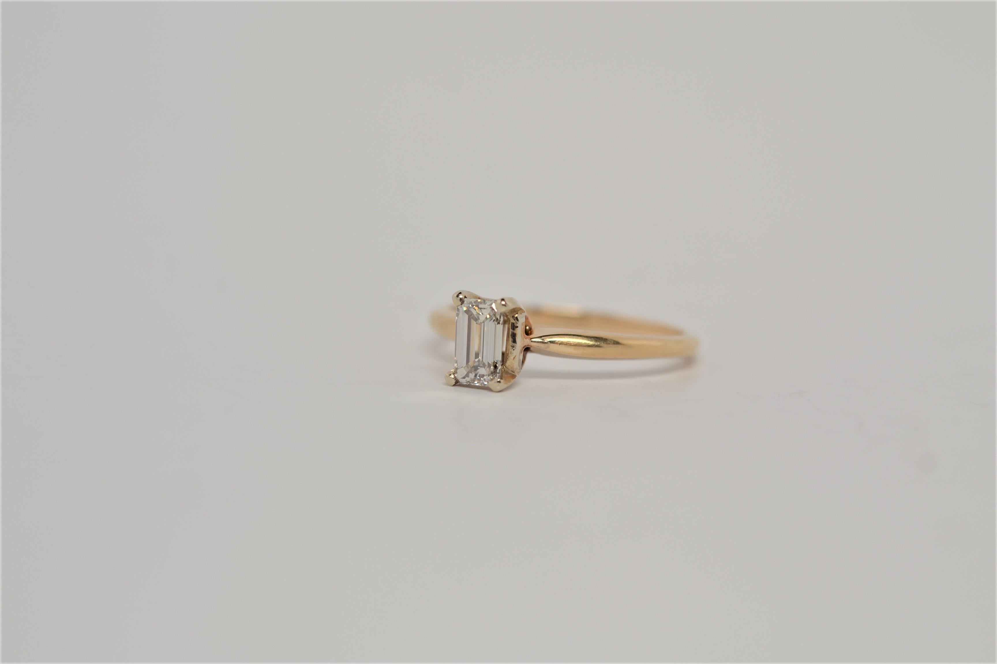 A traditional solitaire engagement ring with Emerald Cut Diamond center. The ring is made in 14K Yellow Gold with a four prong basket to set one diamond. The center is an Emerald Cut Diamond weighing approximately 0.50ct, diamond color grade range K