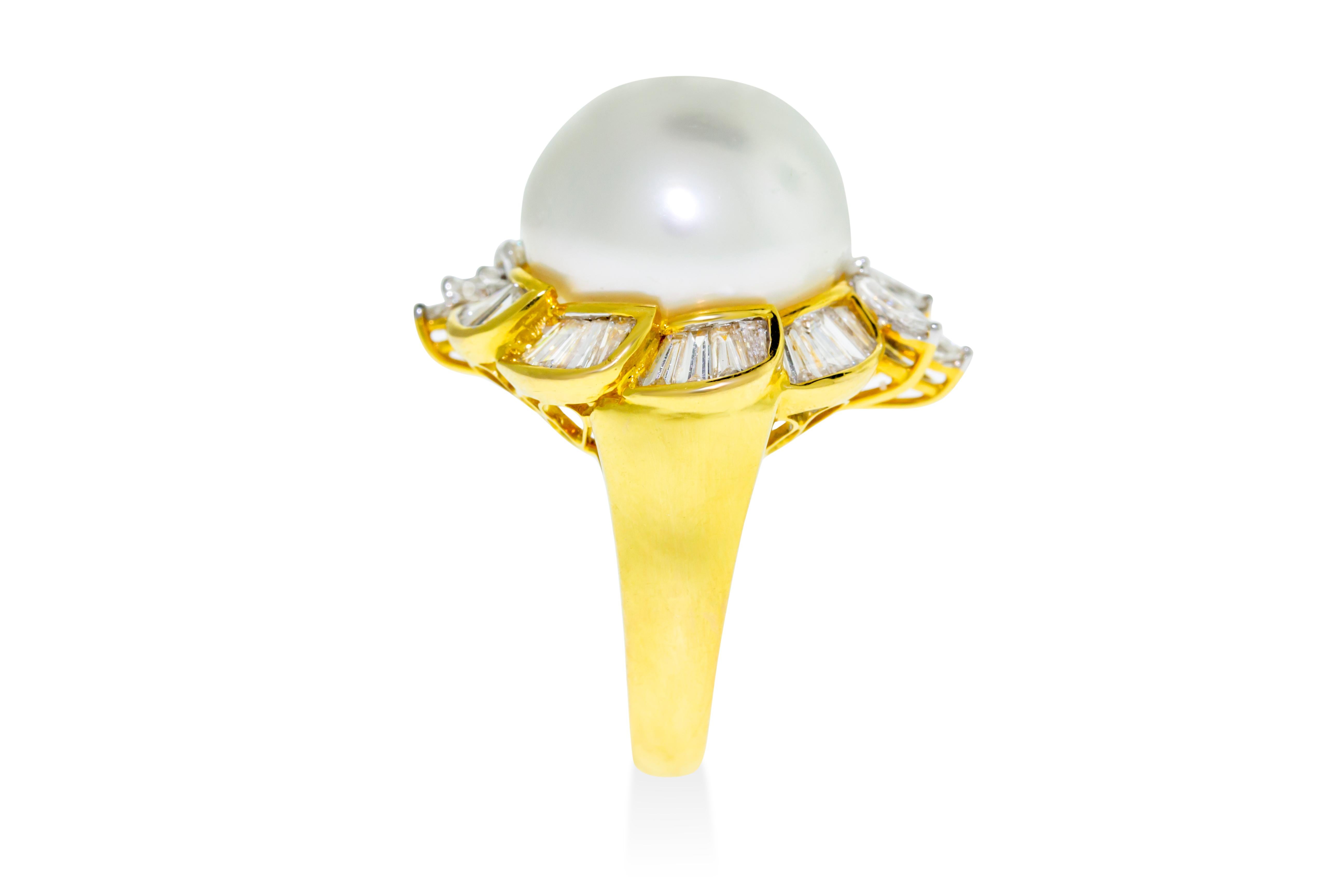 This cocktail ring features a 15 millimeter South Sea pearl set in 13 grams of yellow gold surrounded by 2.45 carats G-H VS marquise and channel set baguette diamonds. Approximately 0.5 inches wide. Size 6. Made in Italy. 

Can be sized down upon