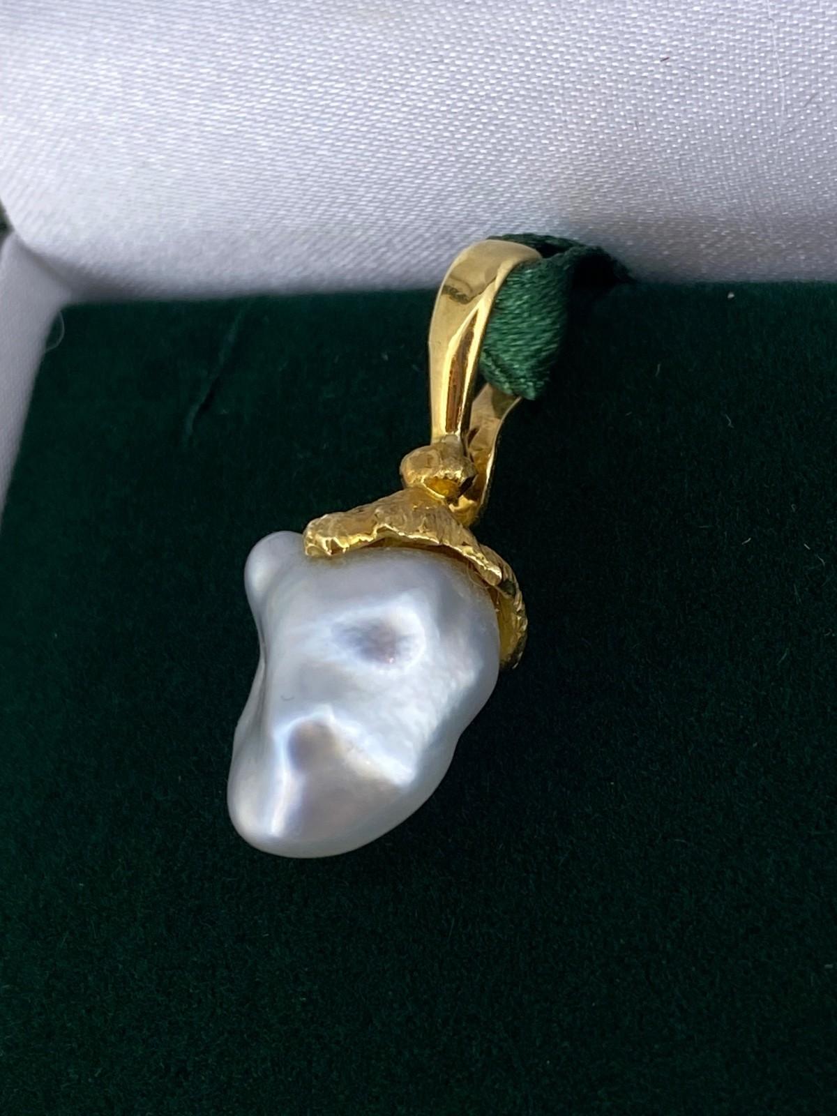 Le pendentif est doté d'un système d'éclairage rarement vu et très recherché. 
Perle baroque des mers du Sud d'une couleur crème éclatante&. 
excellent éclat (peut-être le facteur de valeur le plus important)

Conçu comme un pendentif élégant et