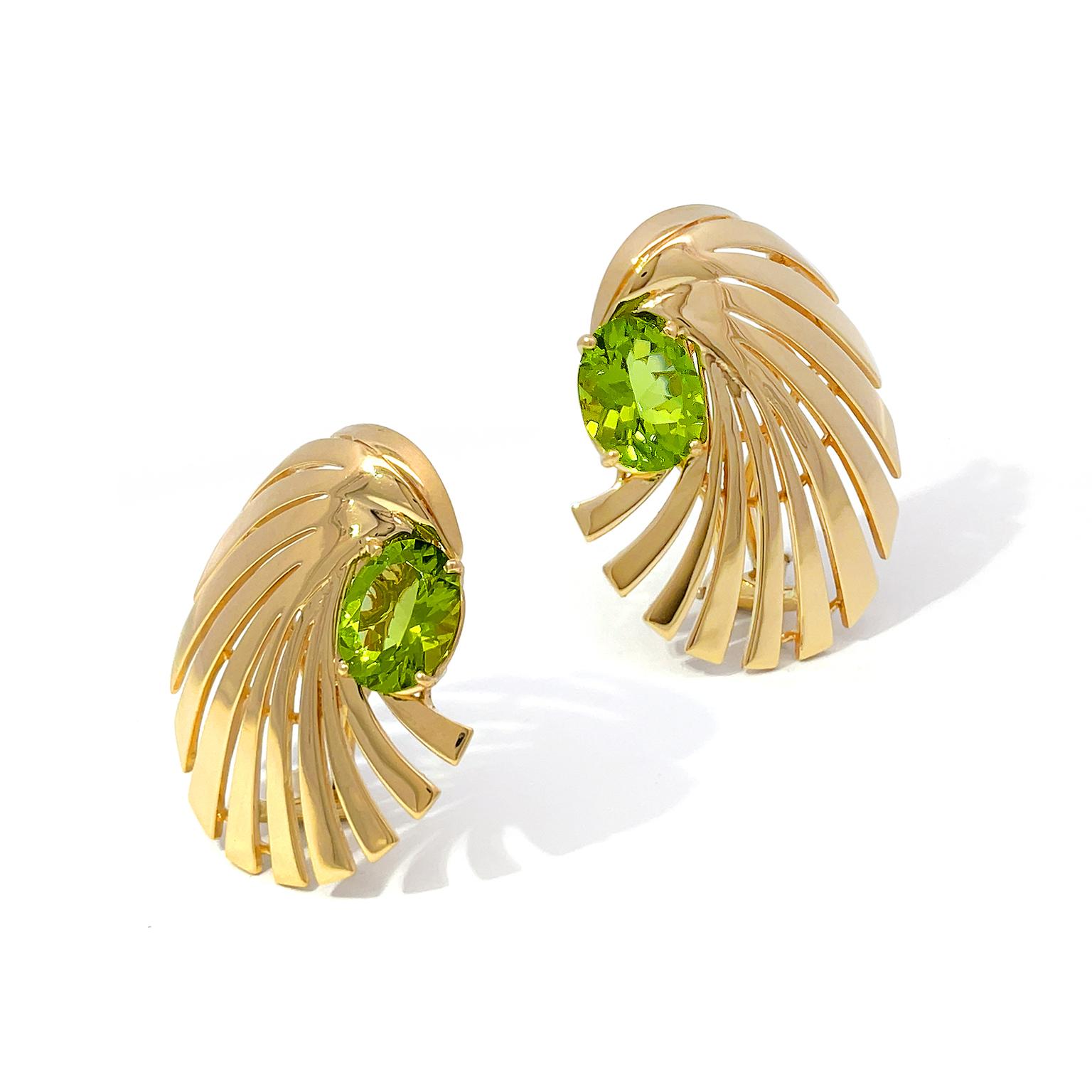 Vibrant yellow-green glitters from an oval peridot in the heart of the motif for these earrings. Rays of 18k yellow gold extend from the jewel and erupt in a rounded spiral pattern. The total weight of the peridots is 5.72 carats. Clip-backs bring