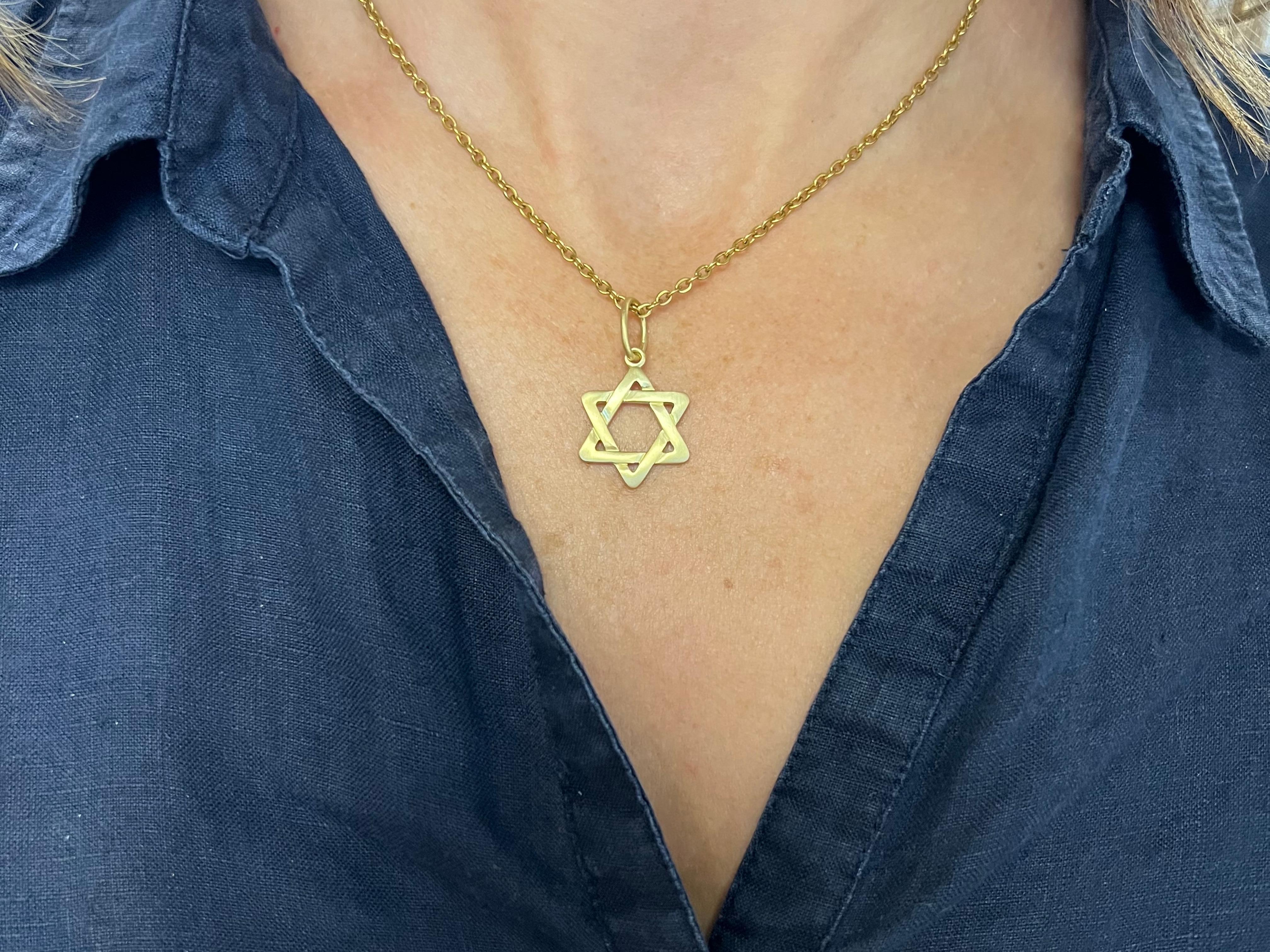 Introducing our exquisite 18k yellow gold Star of David pendant, a timeless symbol of faith and heritage. Crafted with intricate precision, the lines of the star elegantly intertwine, creating a harmonious and captivating design. The points of the