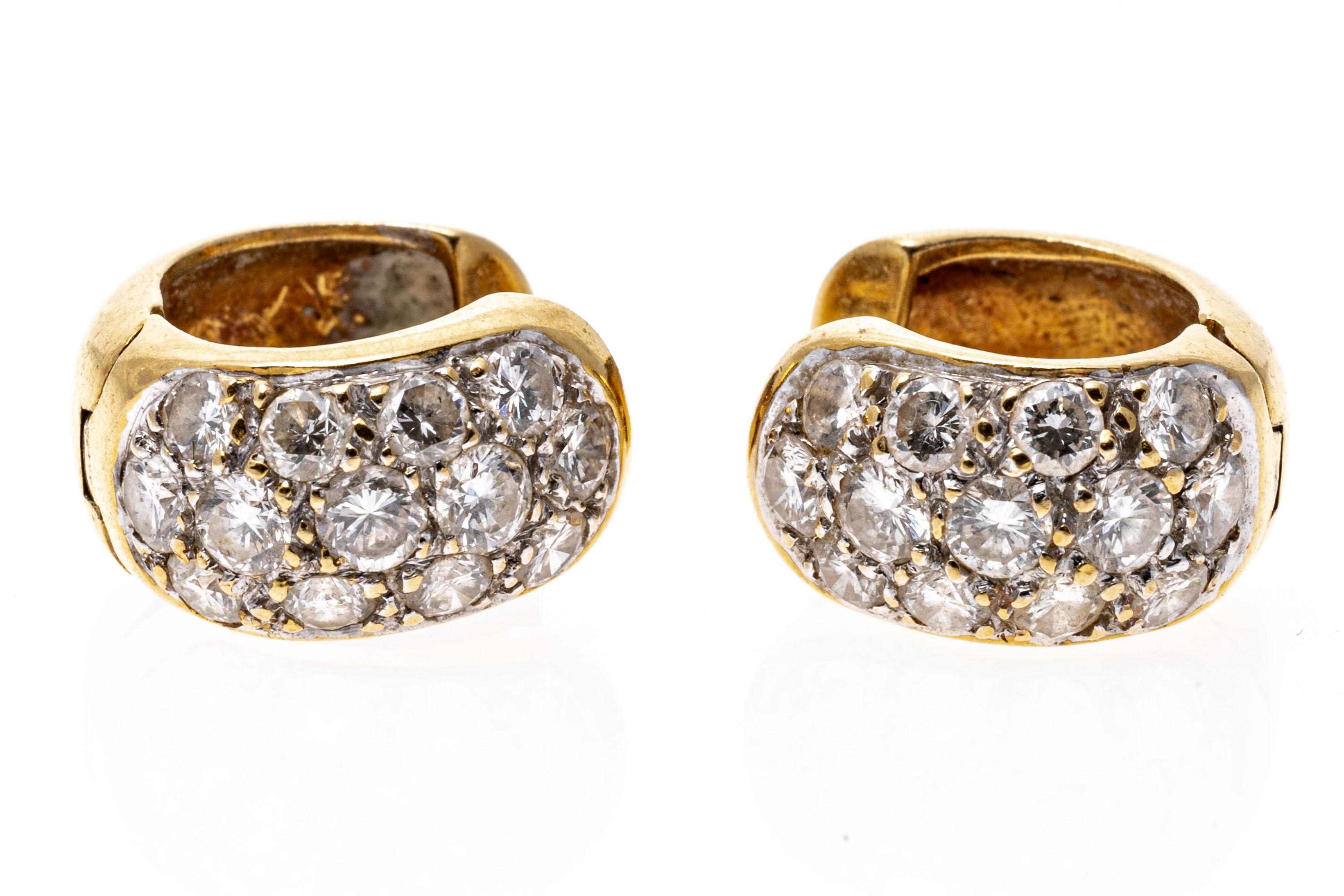 18k yellow gold earrings. These stylish earrings are a huggie style, with a top of pave set, round faceted diamonds, approximately 1.08 TCW. The earrings also have posts, with hinged style backs.
Marks: 750
Dimensions: 7/16