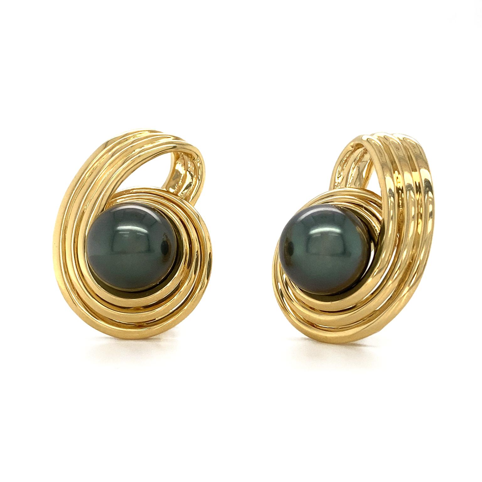 Three bands of 18k yellow gold spiral around a sleek Tahitian pearl and twist back behind the gem for an arresting frame. Clip-backs secure the earrings to the ears. The pearls weigh a combined 29.61 carats and measure 12.70 mm.
