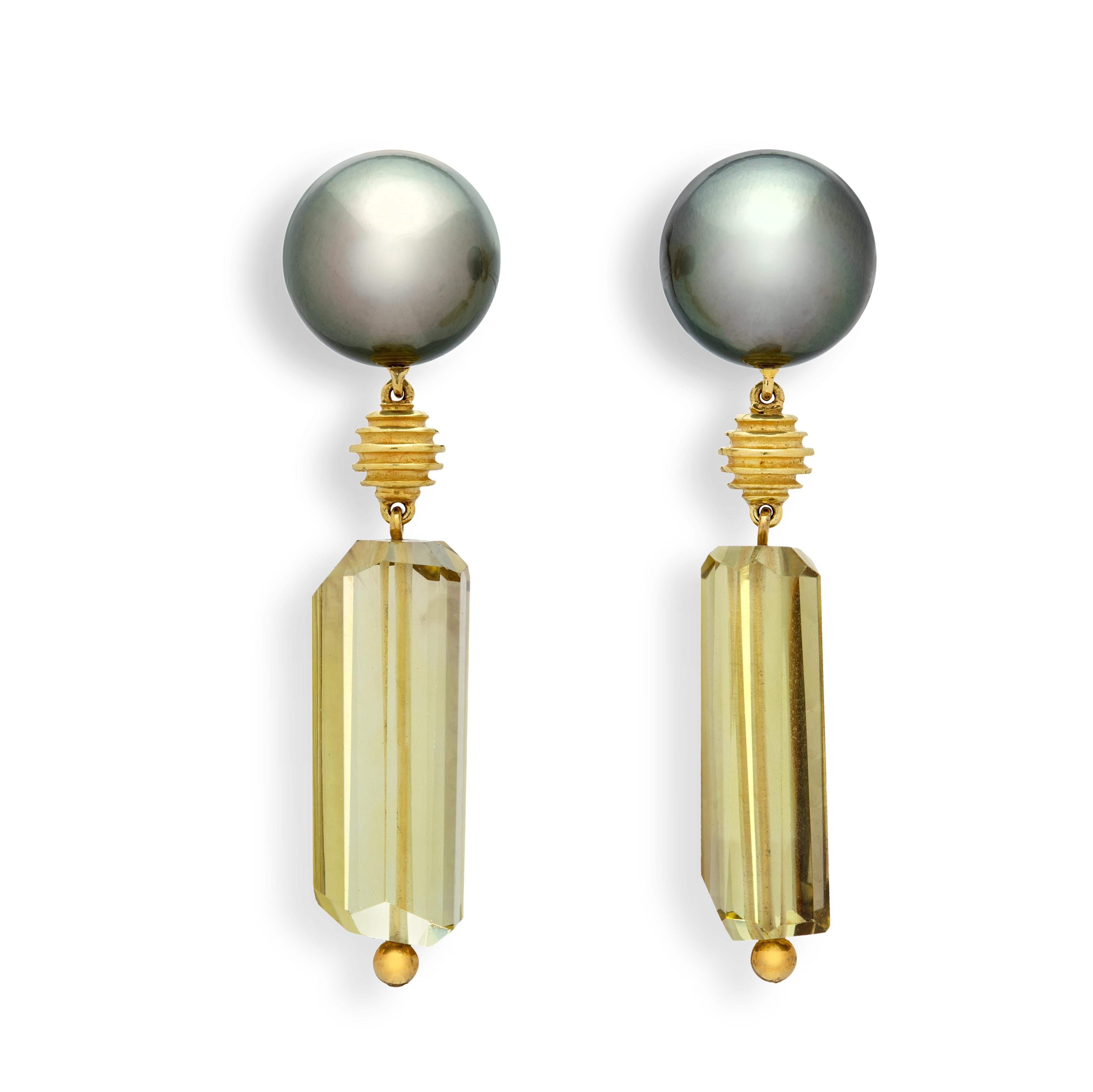 These fun earrings have a futuristic vibe to them that make them so easy to use in any everyday situation. The dark, smooth Tahitian pearls, the carved concentric 18k yellow gold circles, and the bright and clear prasiolite faceted bars make for a