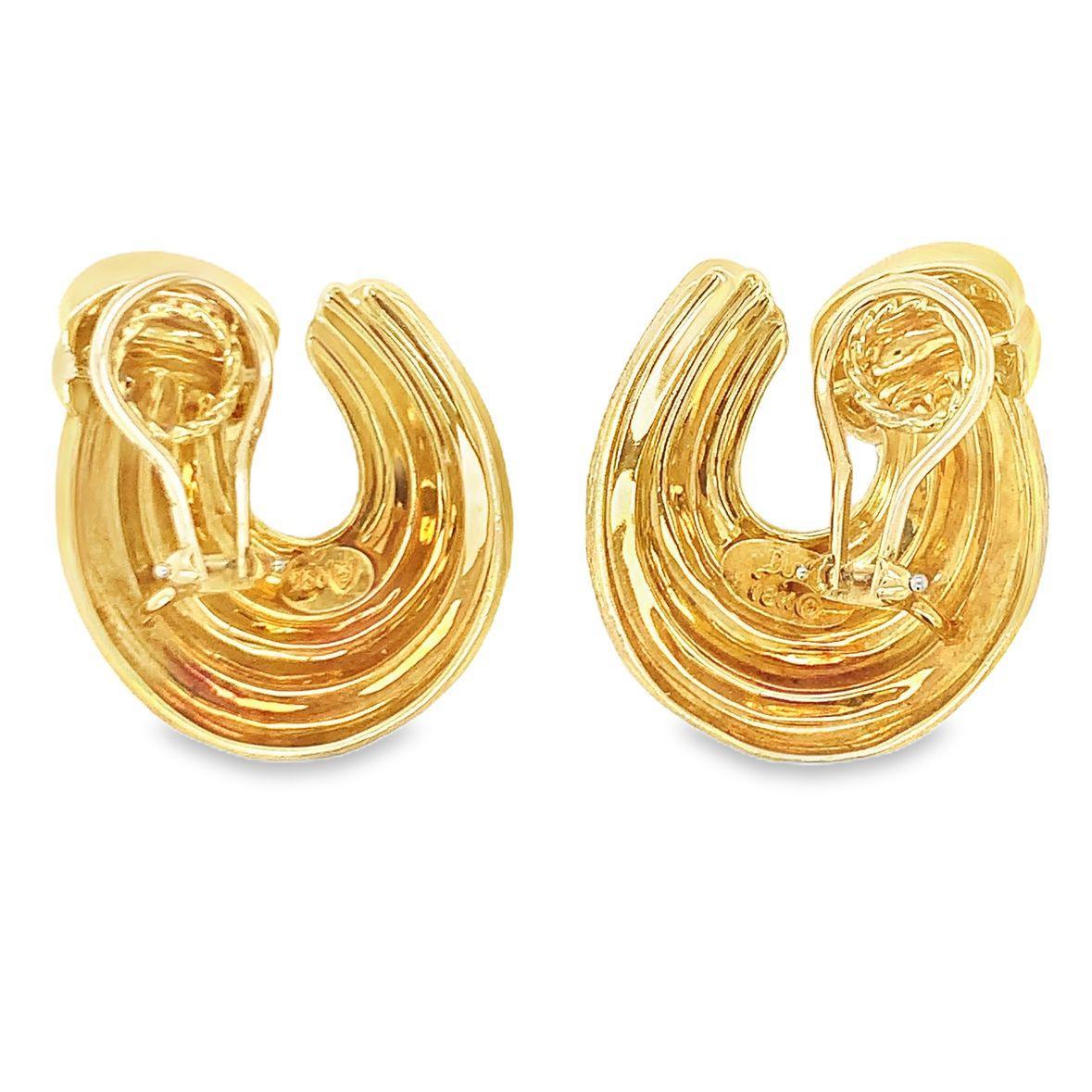Ces exquises boucles d'oreilles en or jaune 18 carats, créées par le célèbre designer Henry Dunay, présentent la finition texturée 
