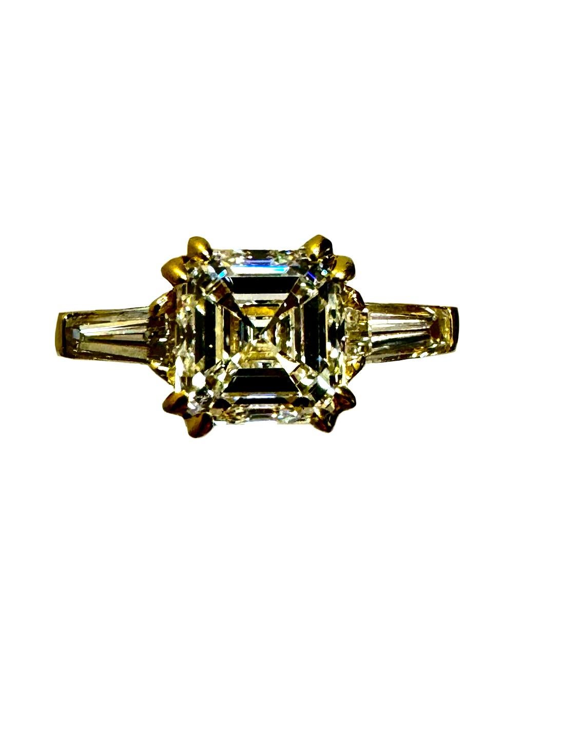 DeKara Design Collection

Metal- 18K Yellow Gold, .750.  90% Platinum 10% Iridium.

Size- 6 3/4.  FREE SIZING!!!!

Stones-GIA Certified Asscher Cut Diamond J Color SI1 Clarity, Two Tapered Baguette Diamonds I-J Color VS2-SI1 Clarity 0.76
