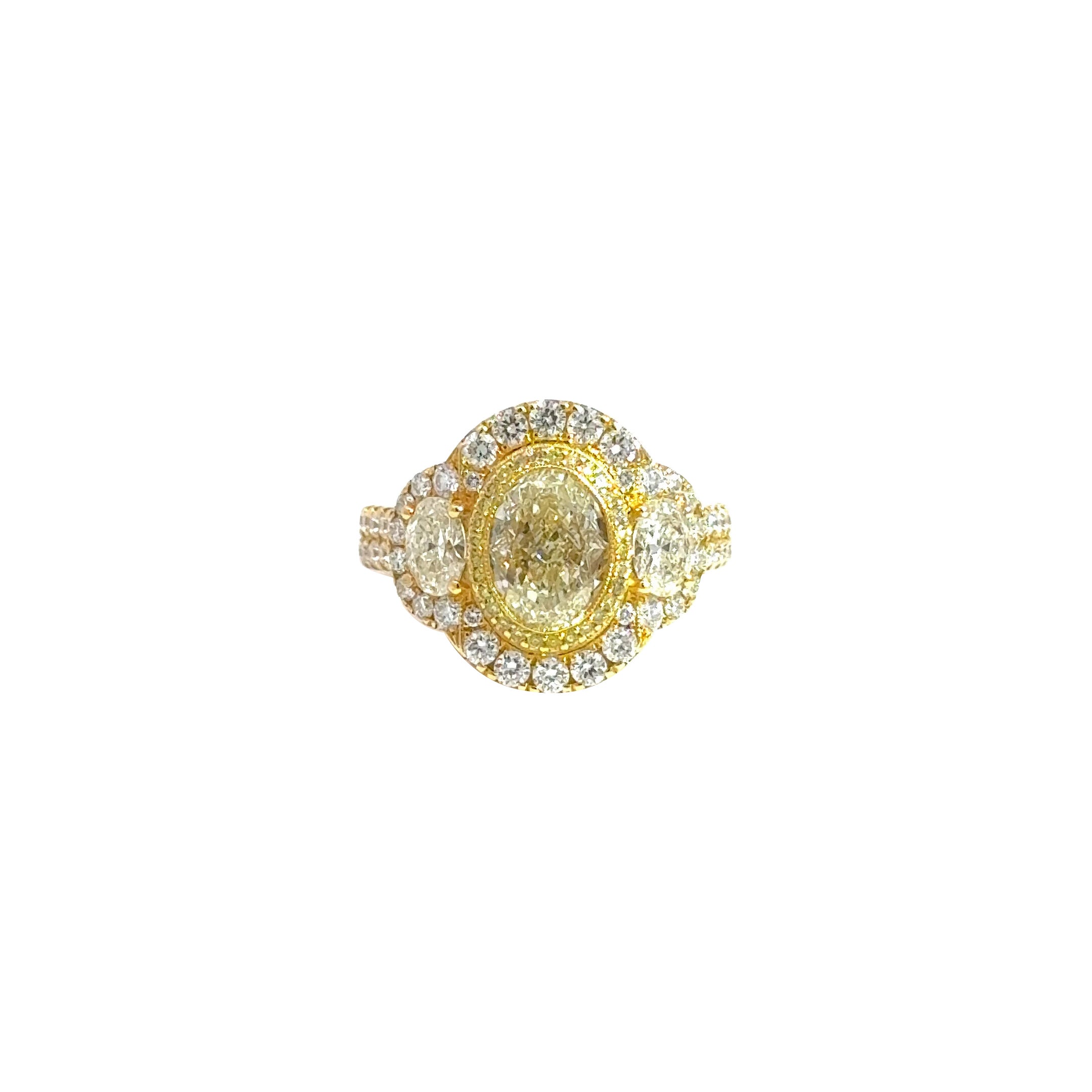 A statement of timeless luxury and intricate craftsmanship, this elegant three-stone ring features a breathtaking 2.05-carat center oval diamond, flanked by two matching ovals totaling 0.68 carats. Surrounding the trio is a brilliant halo of white