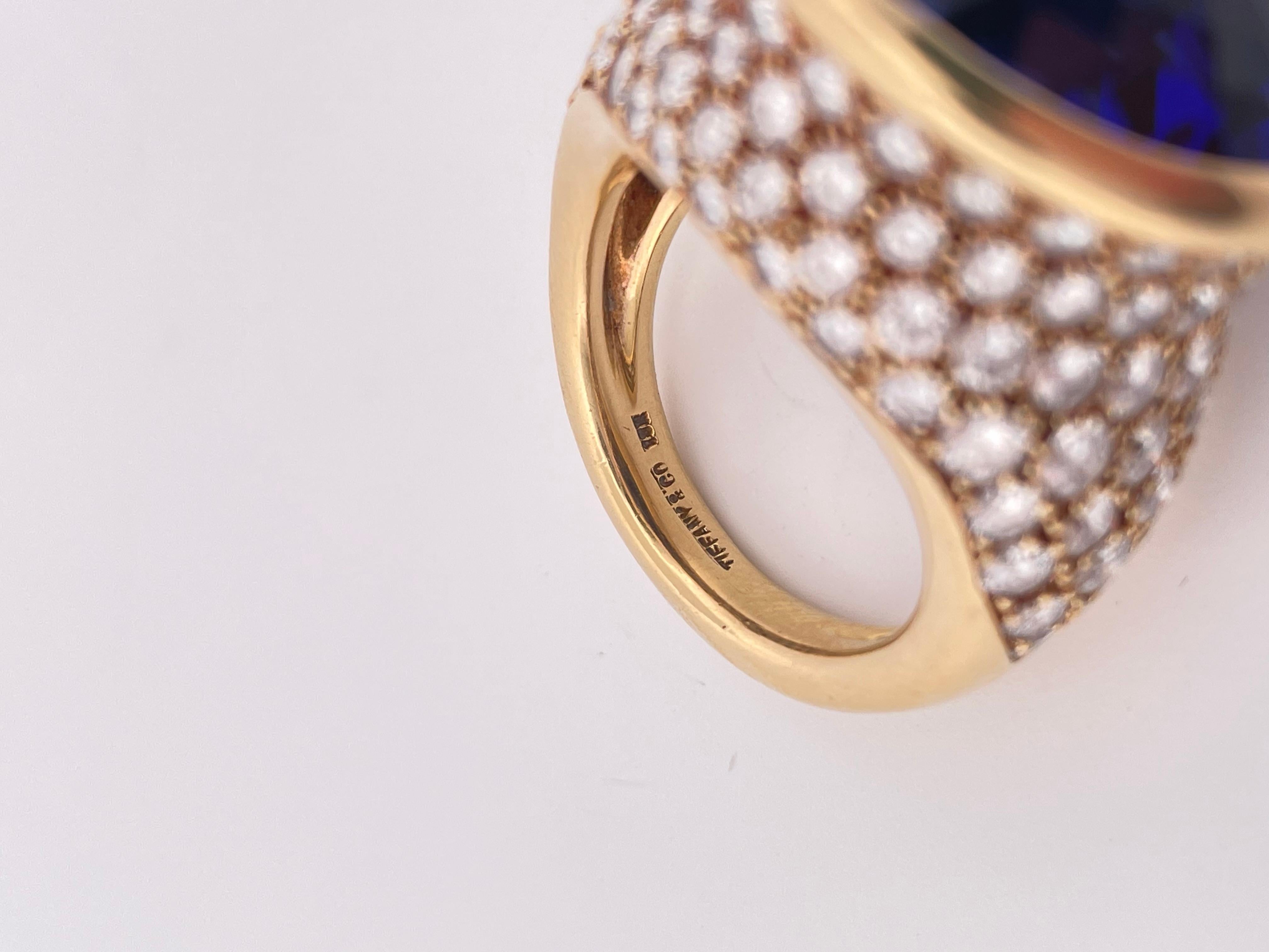 This extraordinary Tiffany & Co. cocktail ring showcases a mesmerizing 31-carat oval-cut Tanzanite, prized for its vivid, deep blue-violet hue and exceptional clarity. Set in warm 18k yellow gold, the vibrant center stone is bezel-set for a bold,