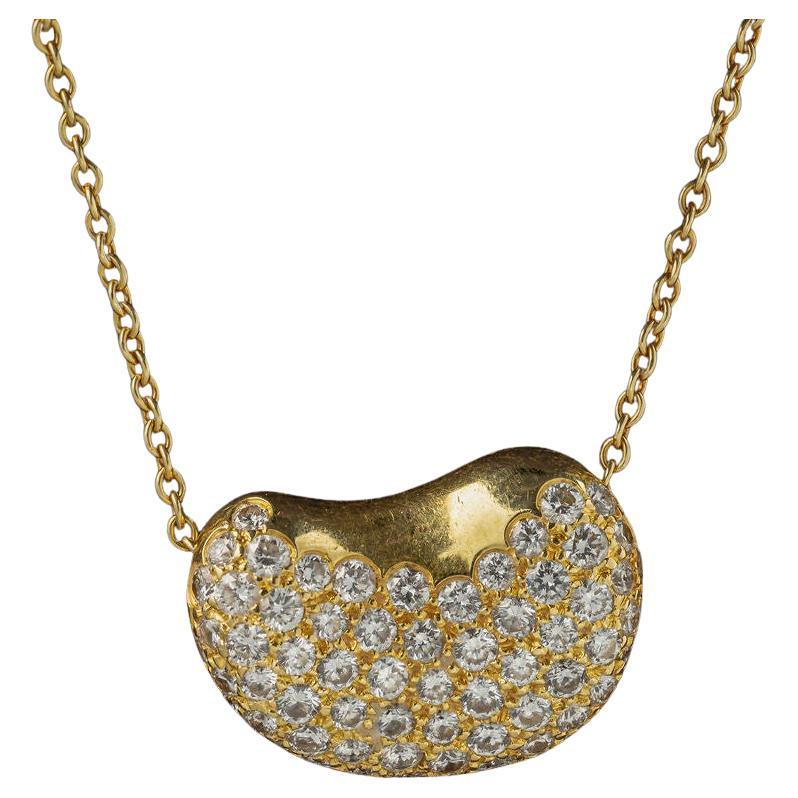 Matériau : Or jaune 18k
Pierre précieuse : Diamant d'environ 1 cttw - pierres dans la monture
Longueur de la chaîne : 16.25 pouces
Dimensions du pendentif en forme de haricot : 15,2 x 12,1 mm 
Poids : 5.3 grammes
Designer : Tiffany & Co. Elsa