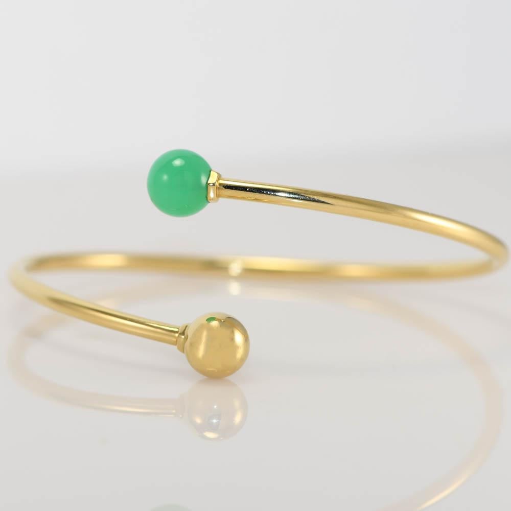Tiffany & Co hardware ball bypass bangle bracelet.
On the side is stamped Tiffany & Co Au750.
Gross weight is 8.4 grams.
The beads measure 8mm.
One bead is green chrysoprase that looks like jade.
The sides of the bangle measure 2.4mm thick.
Medium