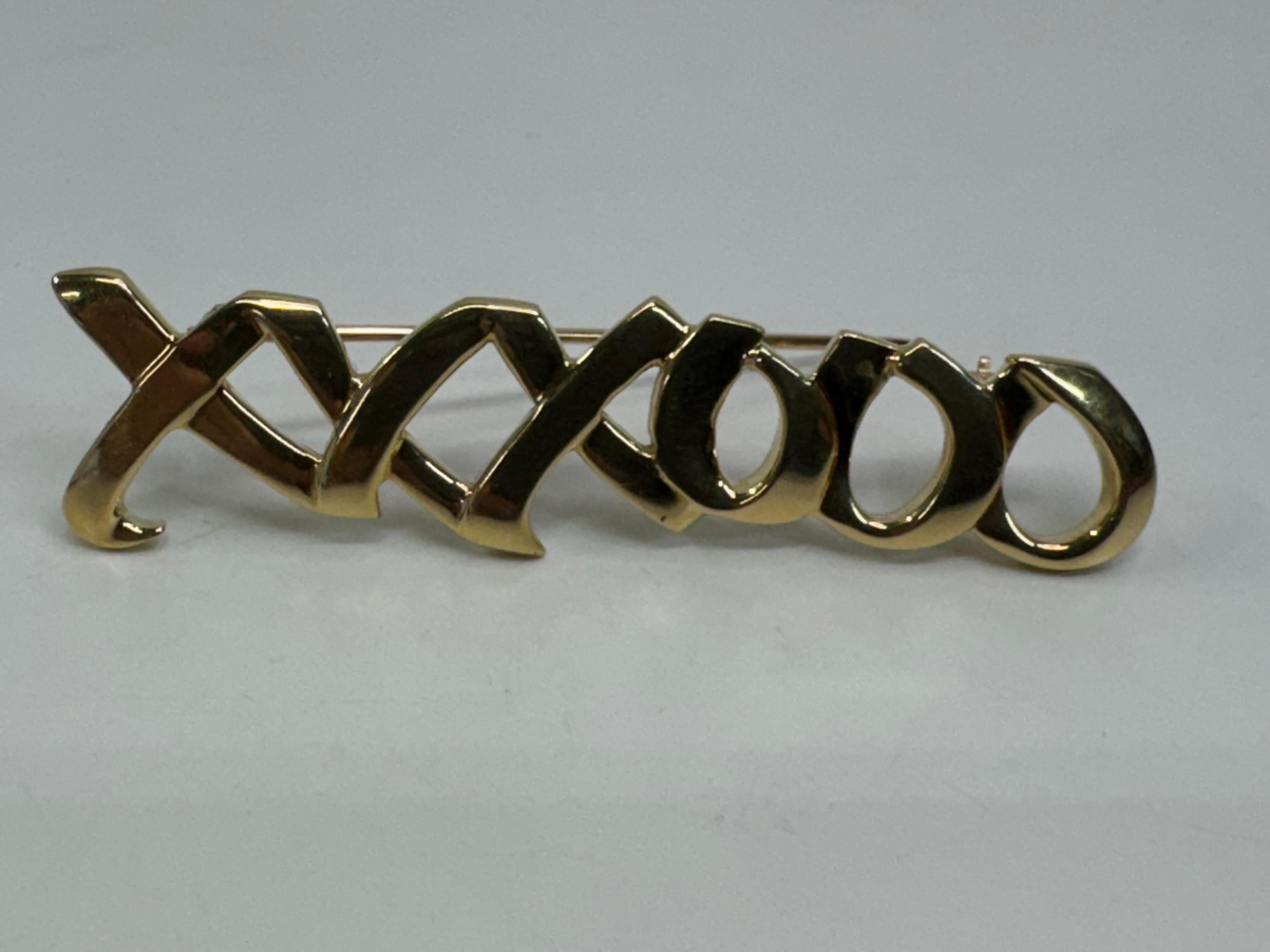Los broches Tiffany XO de oro amarillo de 18 quilates irradian elegancia y sofisticación atemporal. Diseñados por expertos de Tiffany & Co., estos exquisitos accesorios muestran el icónico motivo 