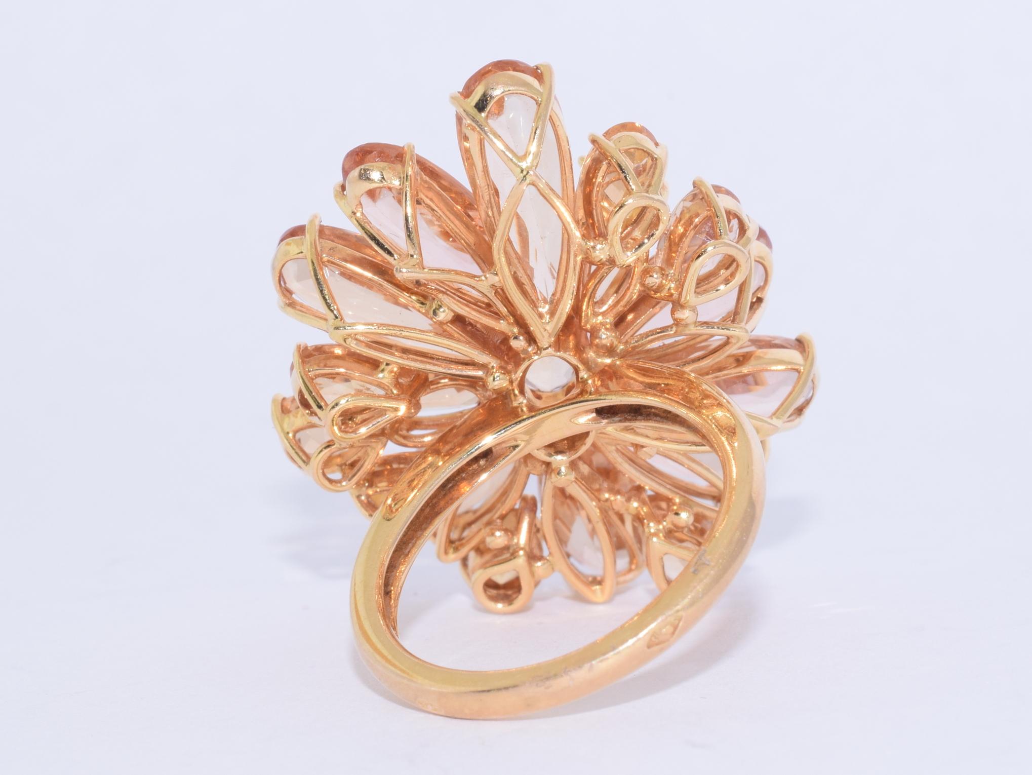 A flowery cluster is formed with pear shape and oval topazes totaling approximately 17 carats mounted in 18 karat yellow gold, with French hallmarks. The head of the ring measures approximately 34 x 26mm and the ring is currently a size 6.5.