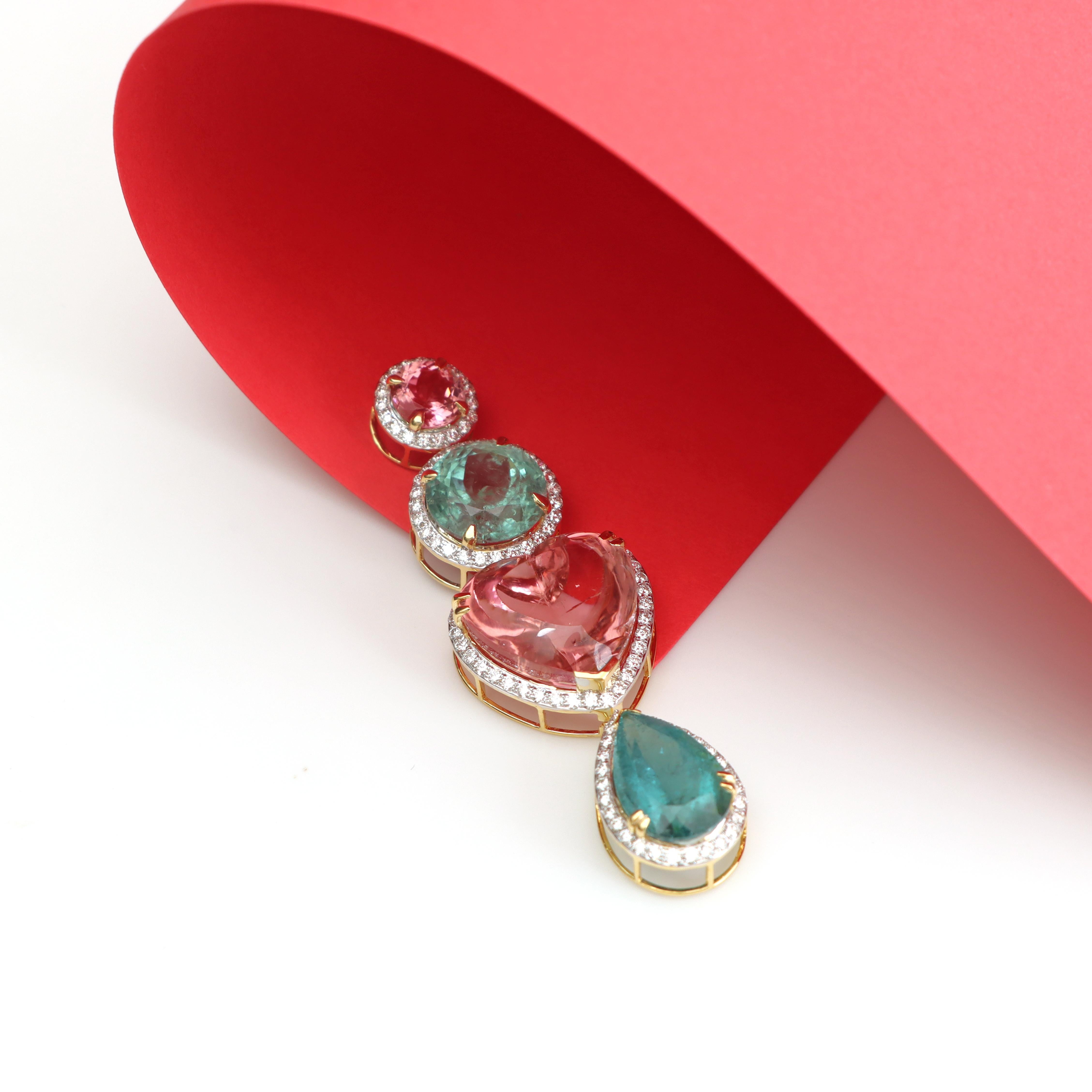 Ce pendentif exquis en or 18 carats présente quatre pierres précieuses vibrantes dans un design vertical, chacune entourée de diamants étincelants. Une pierre ronde rose couronne la pièce, suivie d'une pierre ronde verte, d'une pierre rose en forme
