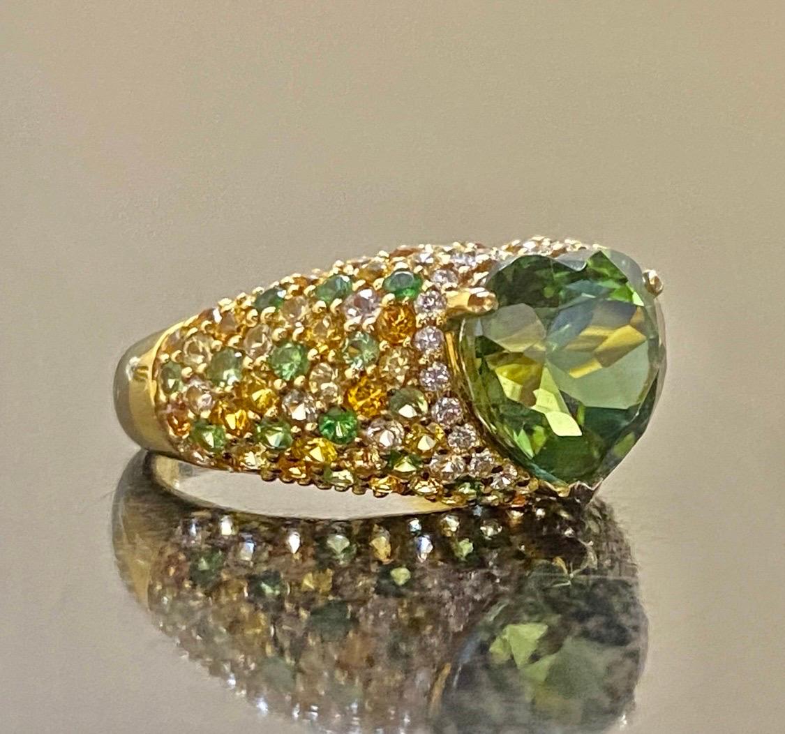DeKara Designs

Metal- 18K Yellow Gold, .750.

Stones- 1 Genuine Heart Shape Green Tourmaline 5.22 Carats, 26 Round Diamonds F-G Color VS2-SI1 Clarity 0.20 Carats, Mix of Round Citrine, Emeralds, and Tsavorites 2.30 Carats.

Size- 7 1/4. FREE