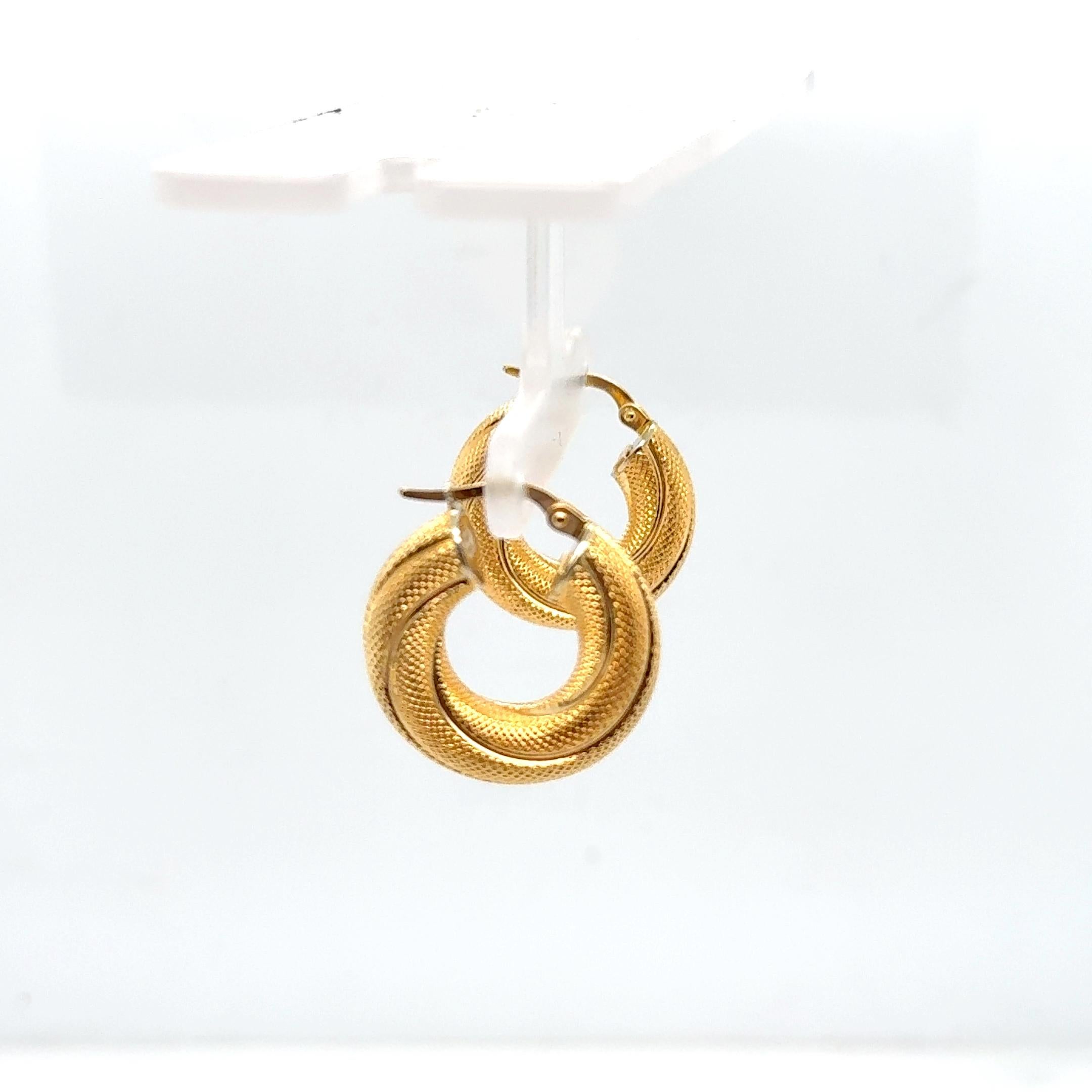 Estos clásicos pendientes de aro trenzado de oro amarillo de 18 quilates muestran un diseño atemporal con un refinado detalle trenzado. Con un diámetro de 21,5 mm y una anchura de 6 mm, los aros tienen una escala atrevida pero ponible, perfecta para