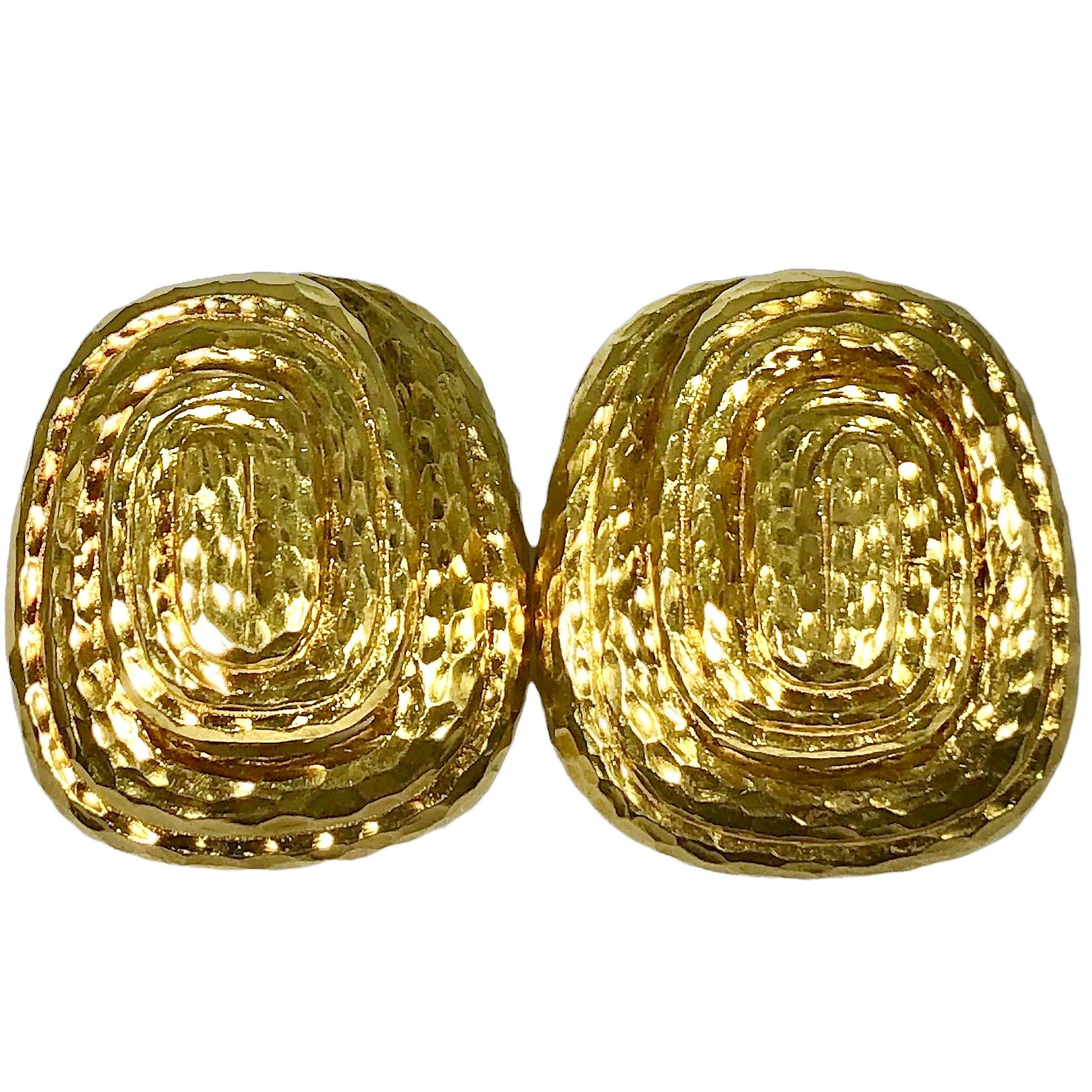 This vintage pair of hammered finish 18K Yellow Gold David Webb clip on earrings are very dimensional, rising to a height of 1/2 inch at their centers. Each earring measures 1 1/4 inches by 1 1/8 inches.  The clip on lever style backs are stamped