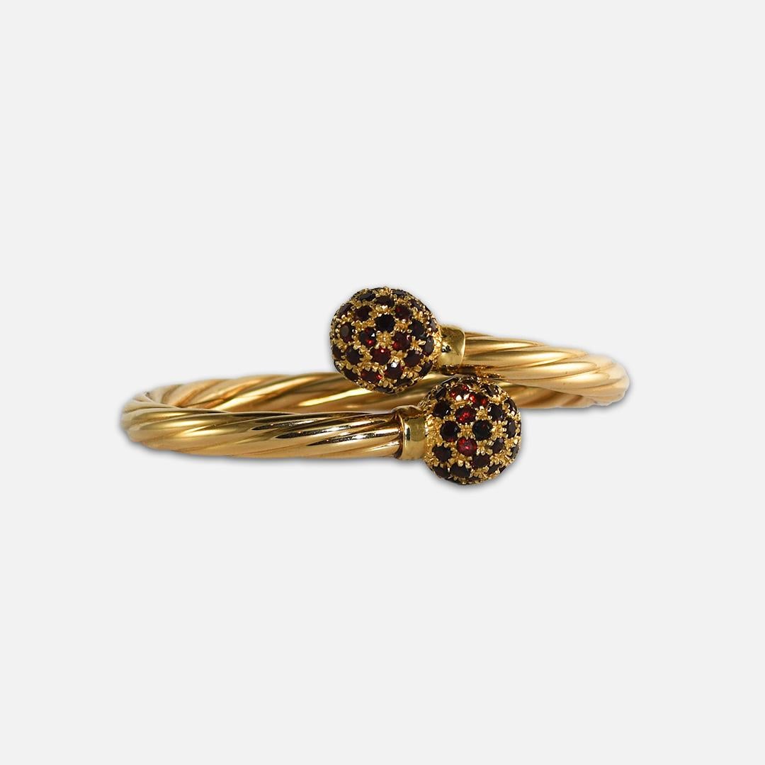 Ladies 18k yellow gold and garnet bangle bracelet.
Stamped 750 and weighs 21.4 grams.
The garnets are an orangy-brown color, round brilliant cuts.
The spiral design bangle measures 6mm thick.
The garnet balls at the end of the bangle measure 13.5mm
