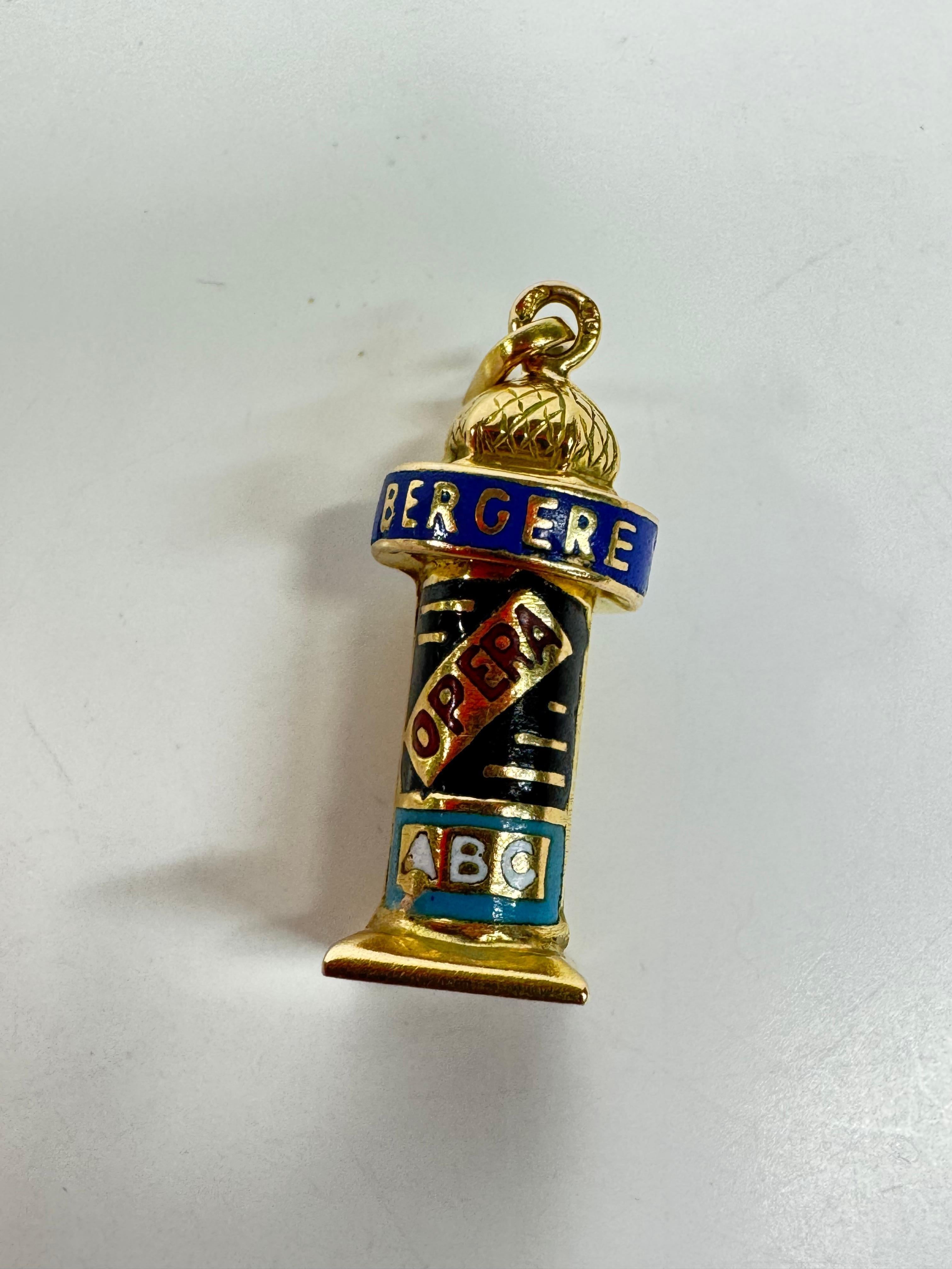 Aggiungi un tocco di fascino parigino alla tua collezione con questo delizioso charm a forma di chiosco vintage di Parigi in oro giallo 18 carati. Sapientemente realizzato con dettagli in smalto colorati e vivaci, questo chiosco in miniatura cattura