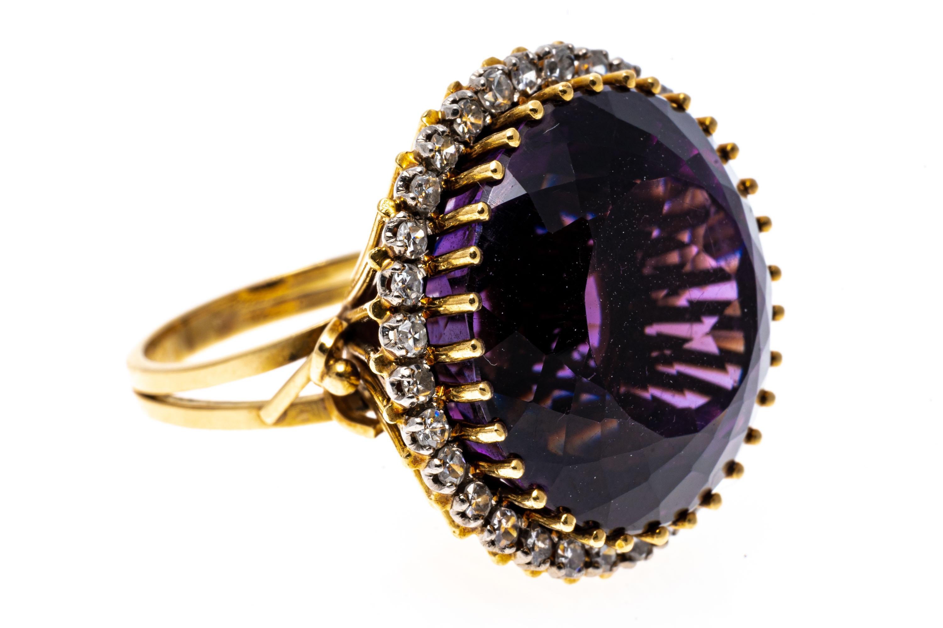 18k yellow gold ring. This amazing vintage ring features a large, round faceted, dark purple color amethyst center, approximately 27.81 CTS and prong sett and surrounded by a round faceted diamond halo, approximately 0.32 TCW, and also prong set.