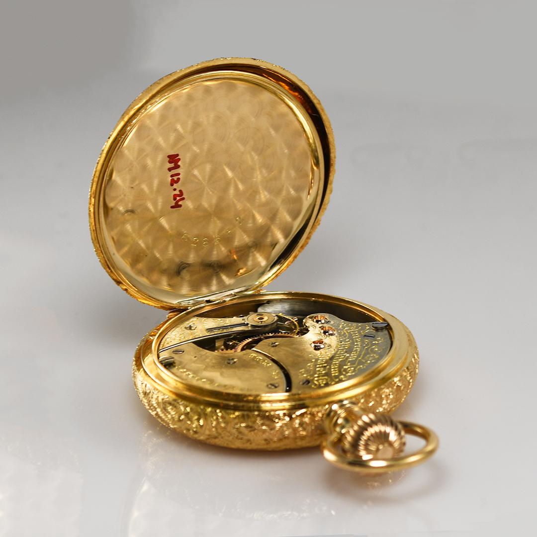 Montre de poche Waltham en or jaune 18 carats avec boîtier de chasse.
Modèle 1890, taille 6, numéro de série 5506199, 15 à 17 rubis.
Mouvement gravé de fantaisie.
Le boîtier est estampillé 18k U.S. Assay.
Le boîtier en or contient 26 grammes de 18k