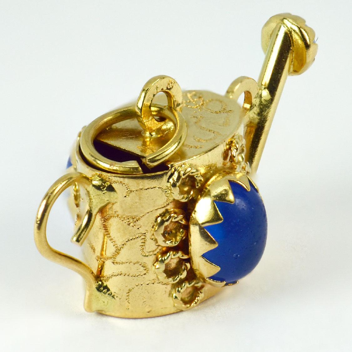 An 18 karat (18K) yellow gold charm pendant designed as a watering can set with blue paste. Stamped 750 for 18 karat gold and Italian manufacture.

Dimensions: 1.6 x 3 x 1.75 cm (not including jump ring)
Weight: 5.66 grams 
