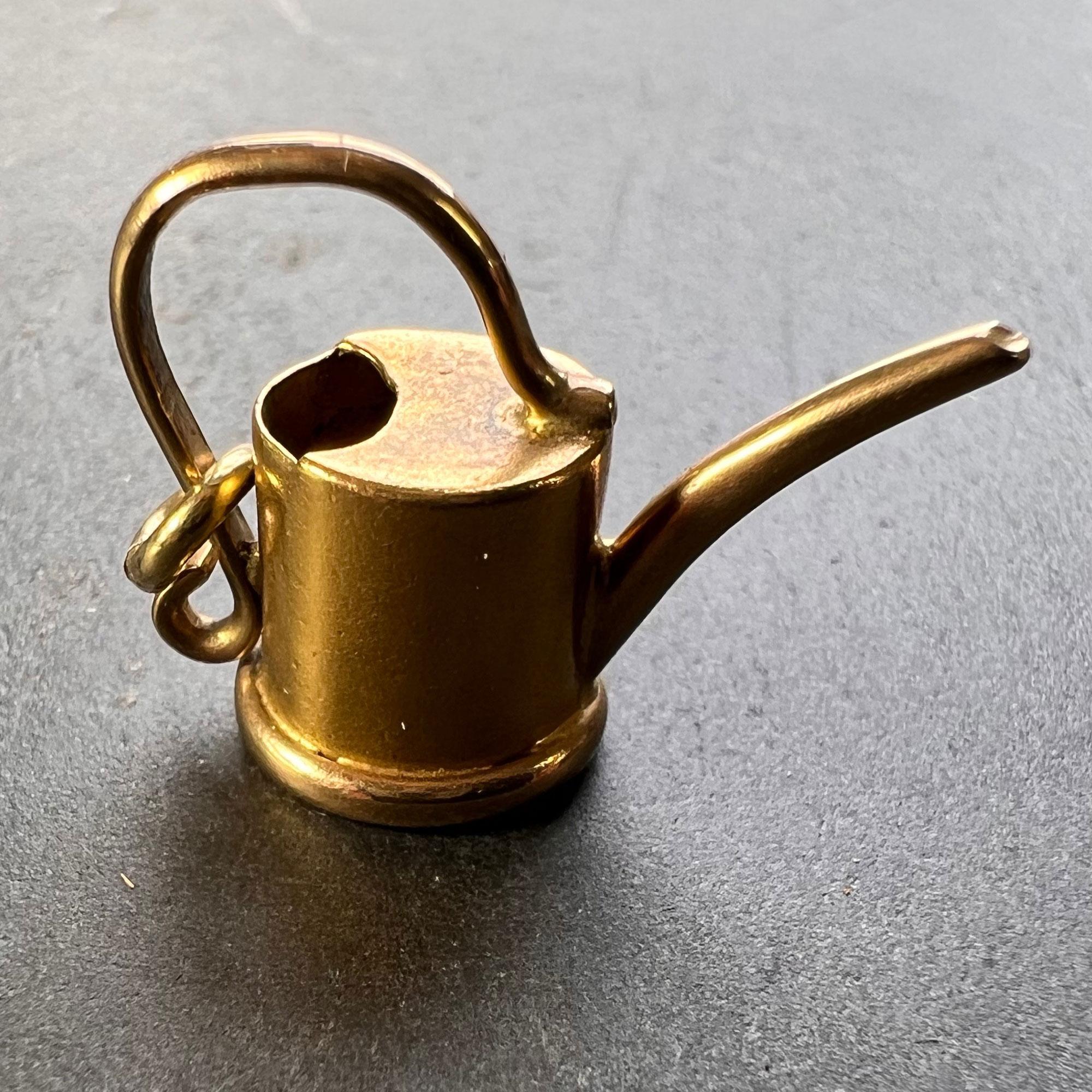 An 18 karat (18K) yellow gold charm pendant designed as a watering can. Stamped with the French import mark for 18 karat gold. 

Dimensions: 1.6 x 2.1 x 0.95 cm (not including jump ring)
Weight: 2.42 grams
(Chain not included)