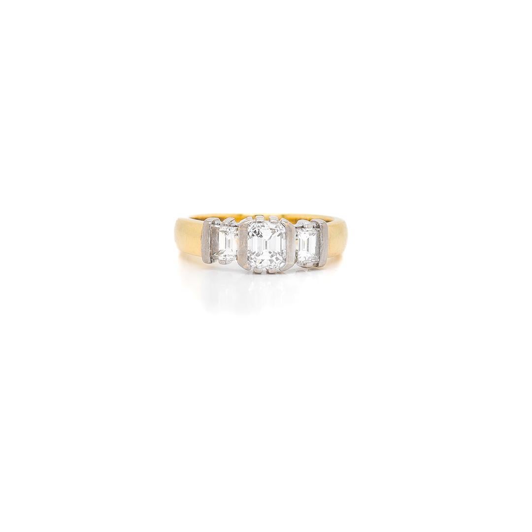 A fine gold & diamond 3 stone ring.

With an 18 karat white gold setting for the diamond on an 18 karat yellow gold band..

With a circa. 0.56 carat rectangular step cut diamond (color: H-I, clarity: VVS2) flanked on either side by rectangular step