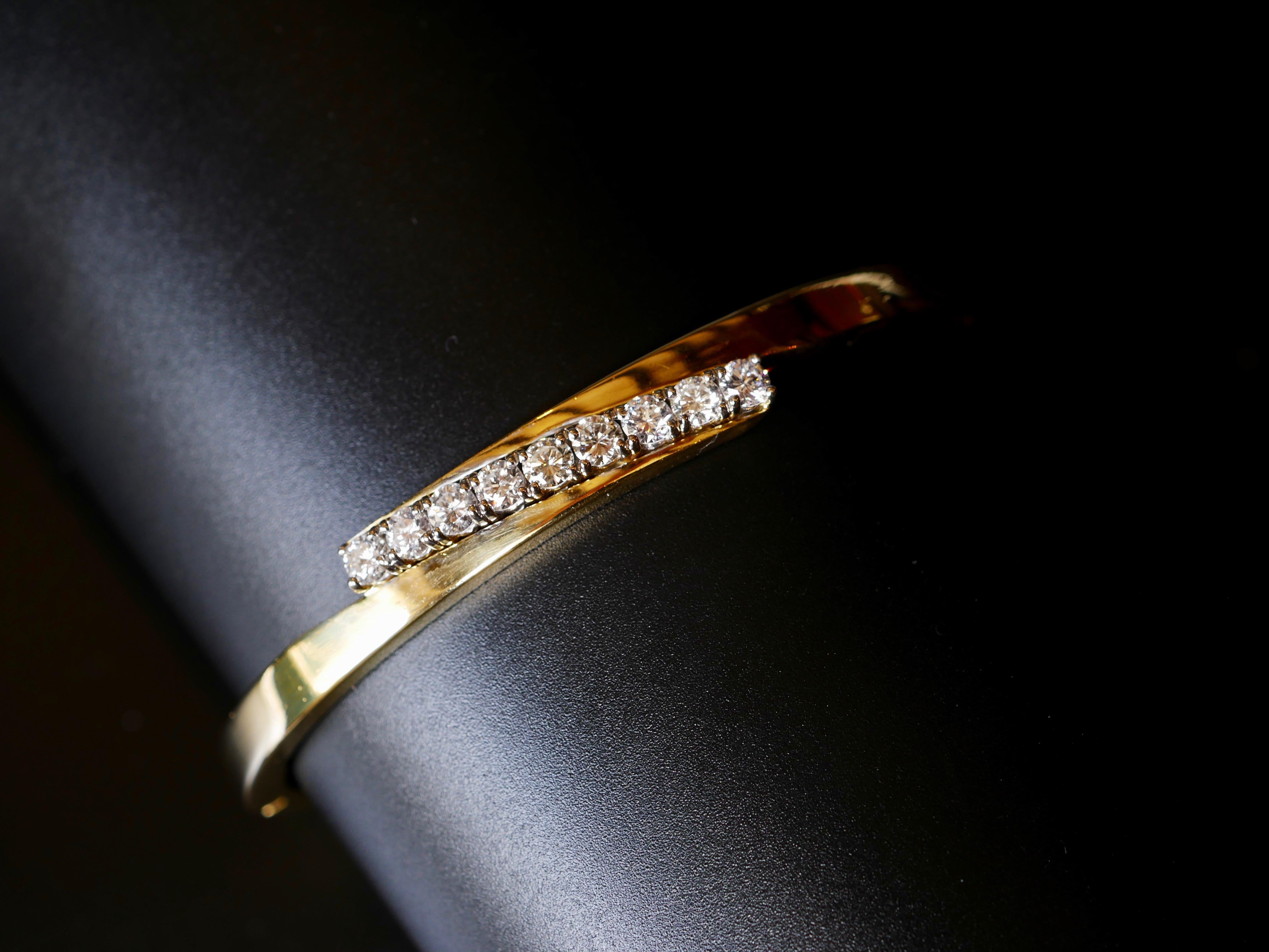 Circa 2000

18k Yellow Gold Bangle 

9 x .10ct Round Brilliant Cut White Diamonds 

Diamonds estimates as G/H VS2 - no visible inclusions under 20x magnification 

