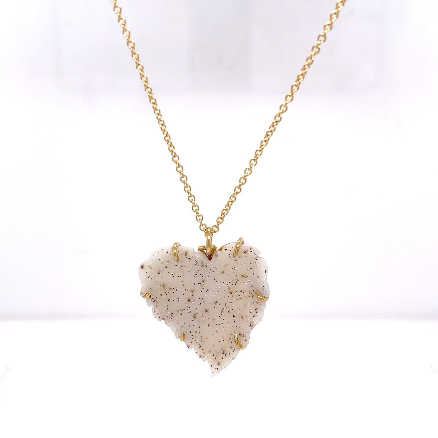 An 18k yellow gold pendant set with one white speckled carved druzy heart, on a 20 inch 1.5mm 14k yellow gold cable chain. This necklace was made and designed by llyn strong.