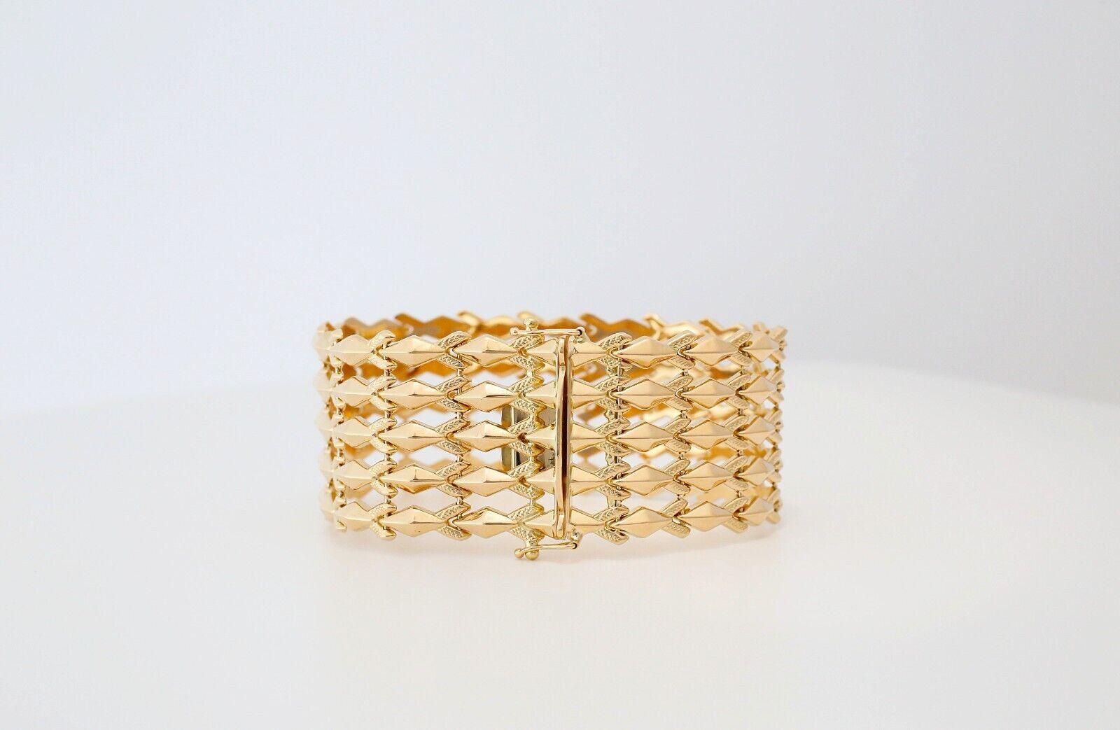 Ce superbe bracelet en or jaune 18 carats met en valeur un travail artisanal complexe dans un large design de style treillis. Composé de maillons répétés en forme de marquise, chaque élément est magnifiquement texturé et poli, créant un luxueux jeu
