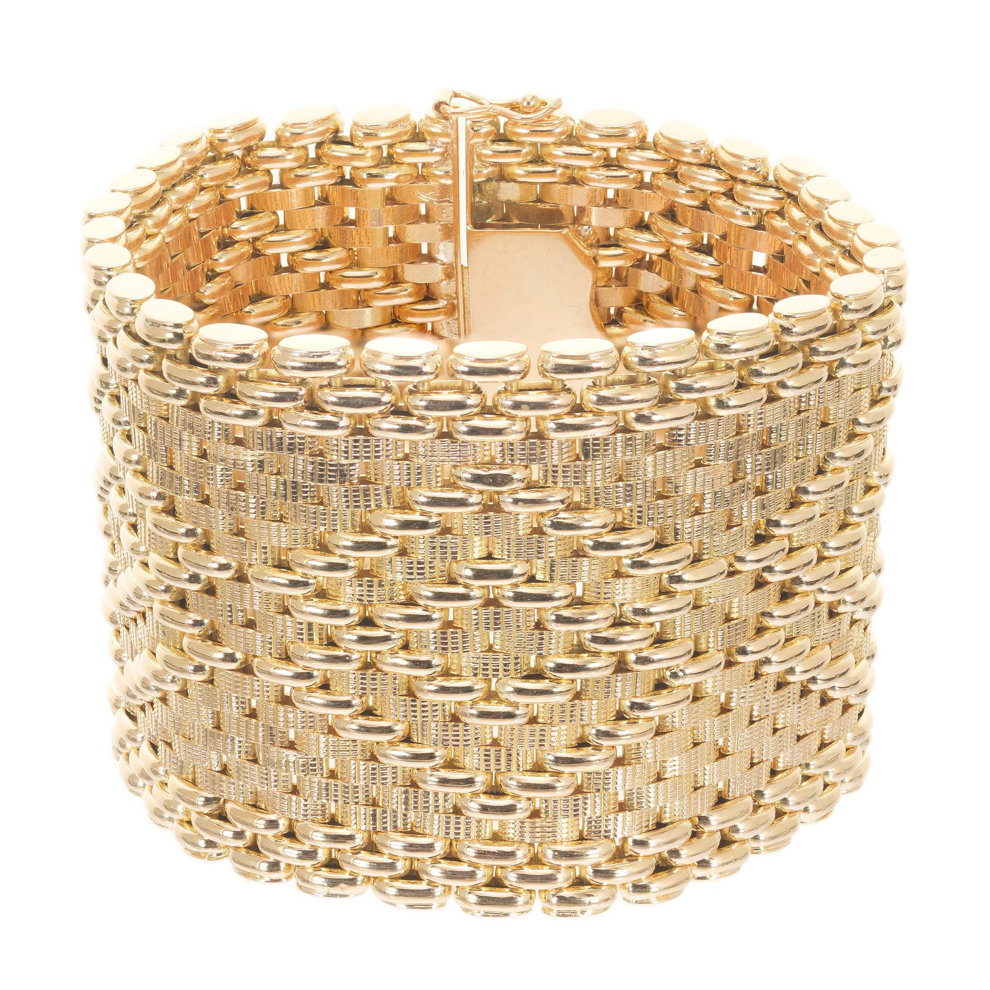 1.75 Inch wide 1970's 18k yellow gold mesh bracelet with a pattern of textured and high gloss links. Hidden built in catch and double side lock safety's. 7.5 inches in length.

18k yellow gold 
Stamped: 750 79-TO
93.2 grams
Bracelet: 7.5 Inch
Width: