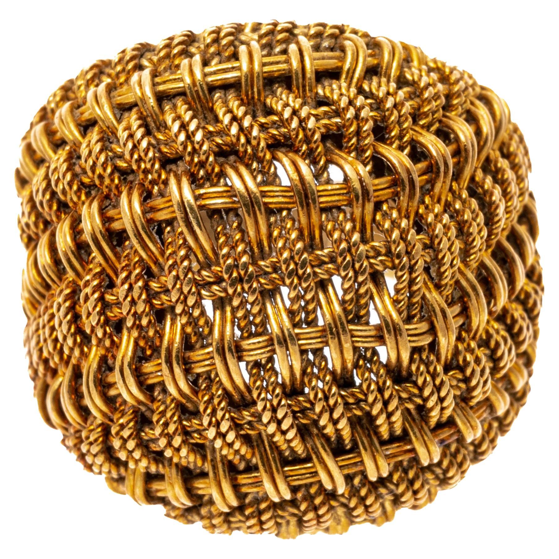 18k yellow gold ring. This interesting ring contains a wide dome style type, featuring a wovern basketweave design, which tapers to the shank in the back.
Marks: 18k
Dimensions: 11/16