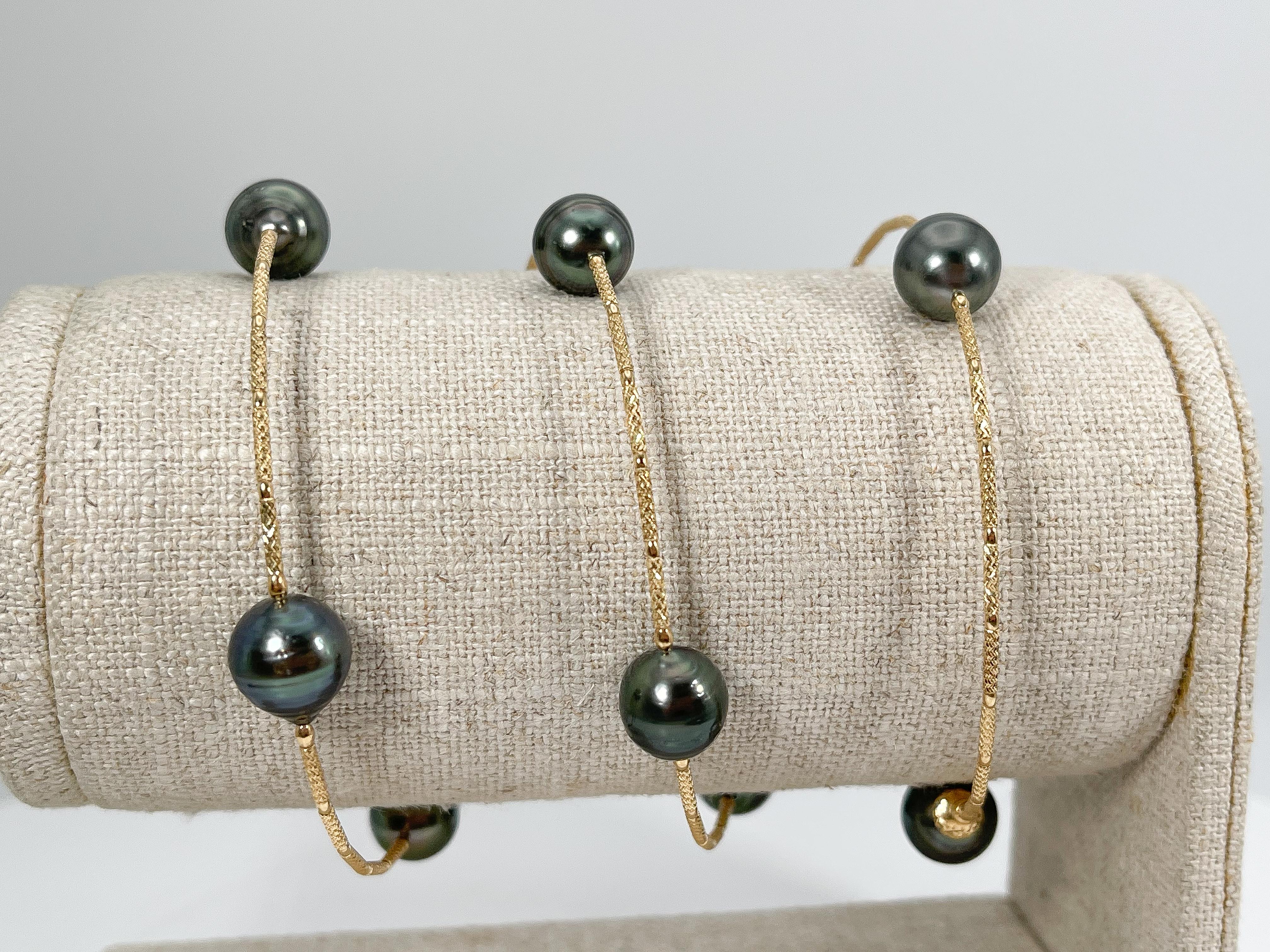 18k yellow gold wire cable black pearl bracelet. This bracelet stretches to fit almost any wrist, the width of the pearls are 9-9 1/2 mm, and it has a total weight of 18 grams.