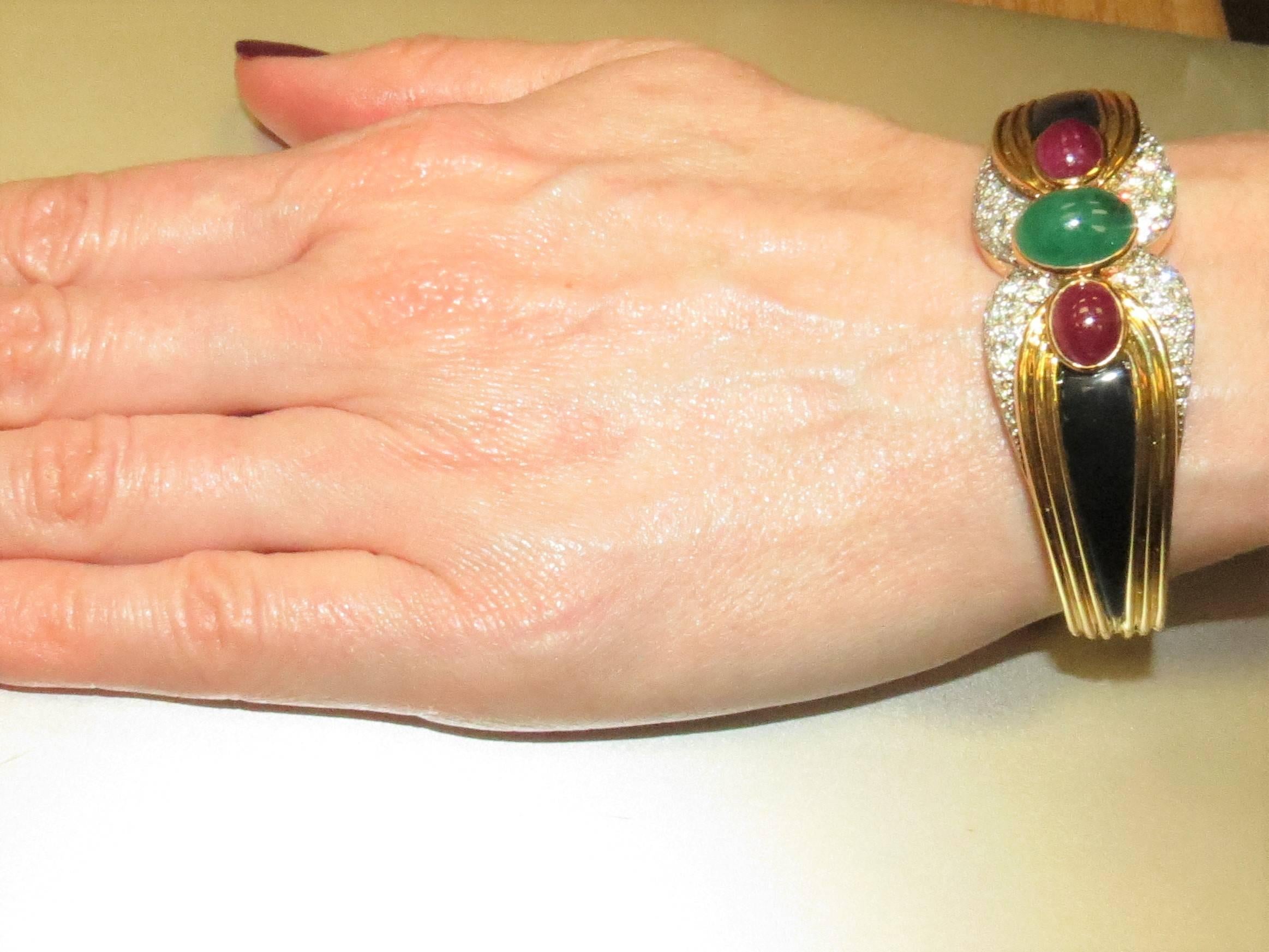 Superbe Montreaux, or jaune et platine 18K  bracelet bangle en onyx noir pavé de 64 diamants ronds pleine taille, pesant 2.46 cts, couleur D-E, pureté VVS,  et deux rubis cabochon sertis en lunette pesant 5.54cts et une émeraude cabochon sertie en