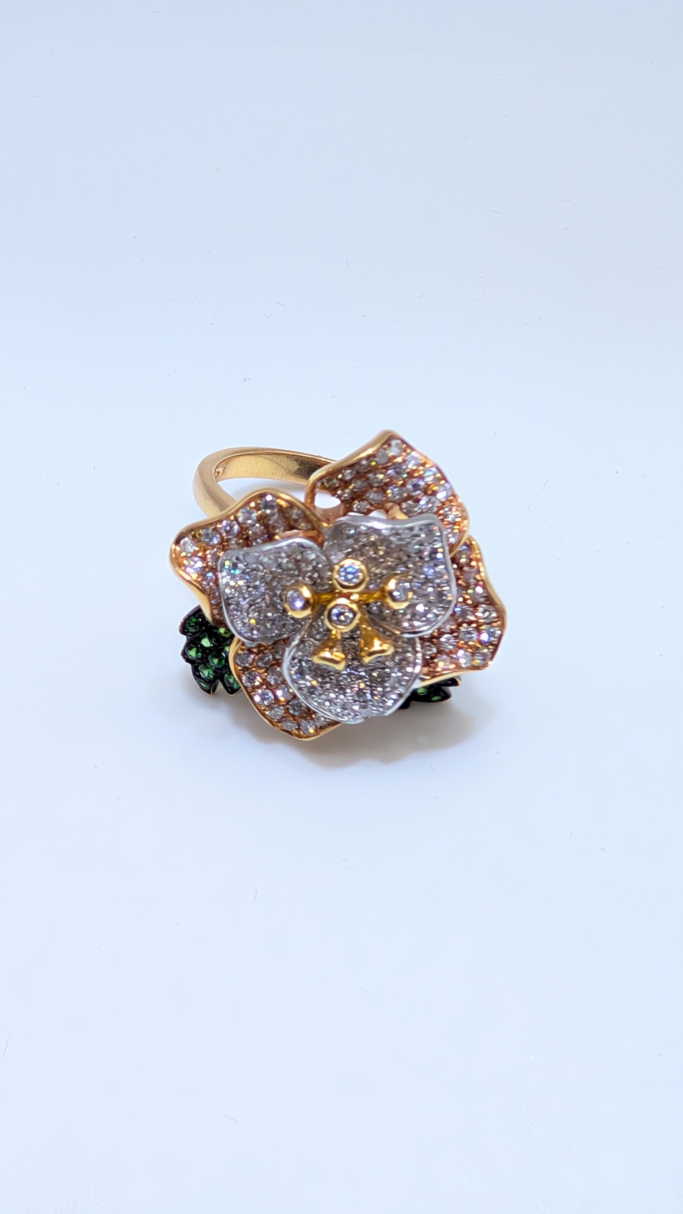 This stunning 18-karat gold ring showcases a beautifully detailed floral design with petals crafted from rose, yellow and white gold. The rose gold petals are adorned with dazzling diamonds, adding a brilliant sparkle, while the white gold petals