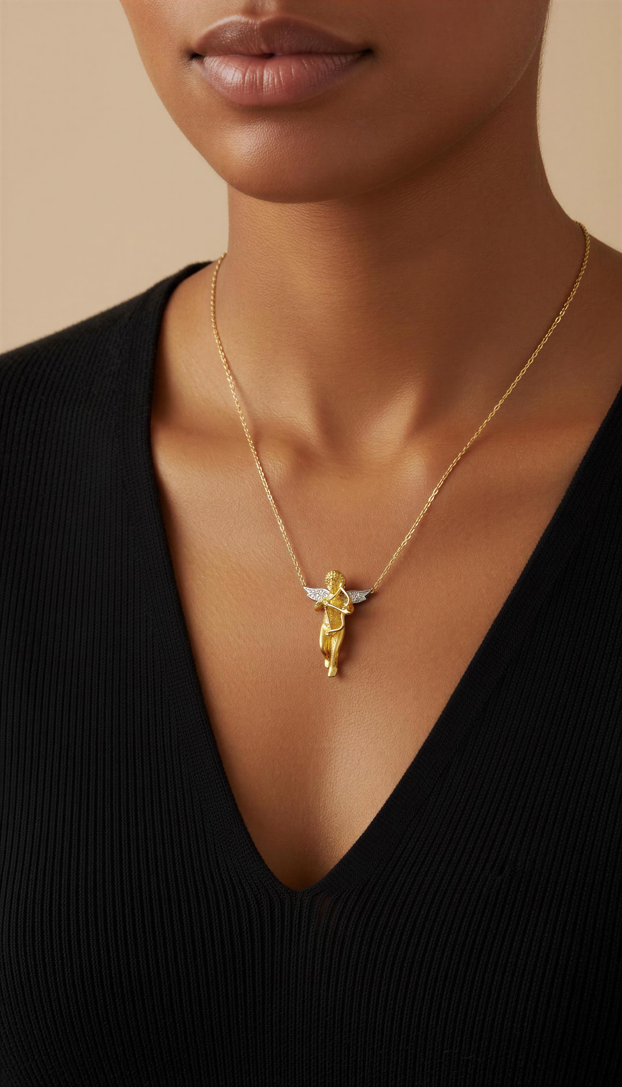 Cherub oder Amor, der einen Pfeil und Bogen hält, steht  bereit, einen geliebten Menschen zu treffen. Diese charmante Halskette mit Anhänger ist aus 18 Karat Gelbgold gefertigt und mit Flügeln aus 18 Karat Weißgold versehen, die mit 6 kleinen