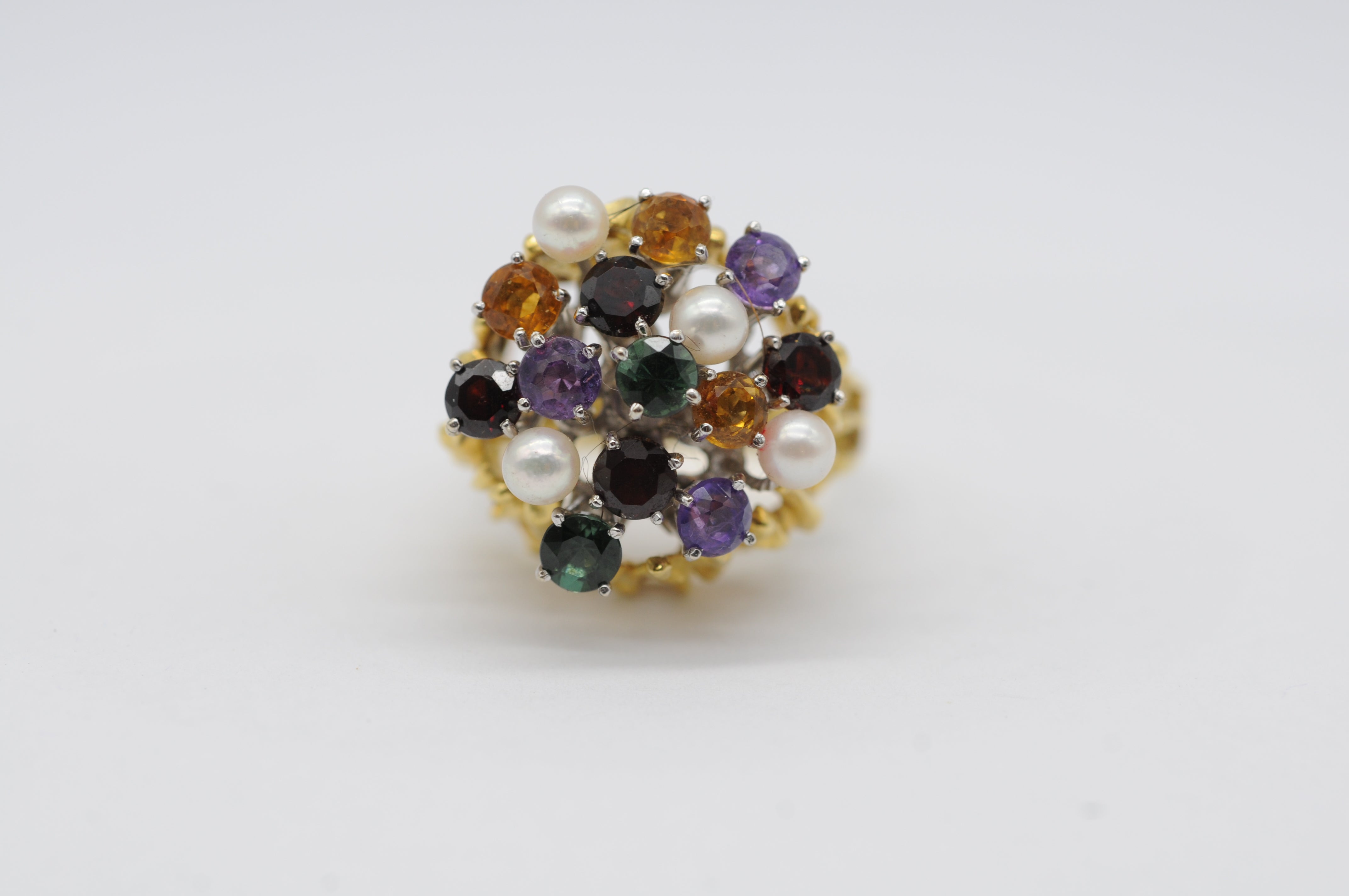 Questo splendido anello da cocktail a 18 carati, realizzato in una splendida miscela di oro giallo e bianco, presenta un design intricato e senza tempo che si fa notare. Adornato da un'abbagliante gamma di gemme, tra cui due vibranti tormaline, tre