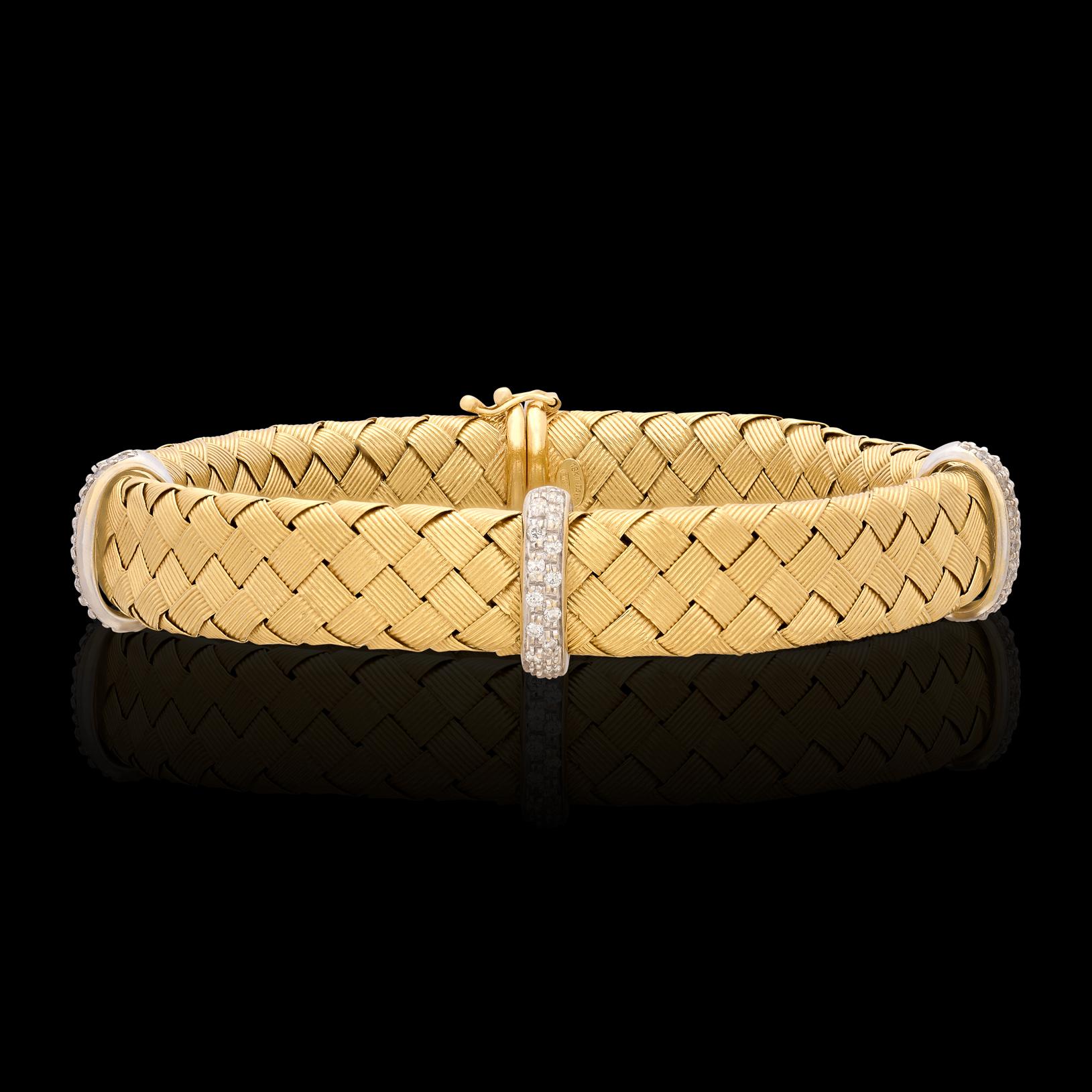 Style for days! This fashionable two-tone 18 karat gold bracelet features 0.40 carats of accent diamonds and a rich blue cabochon cut sapphire, perfectly set amongst a mesh style gold bangle. The bracelet weighs 34 grams and is a size 7 1/2. The