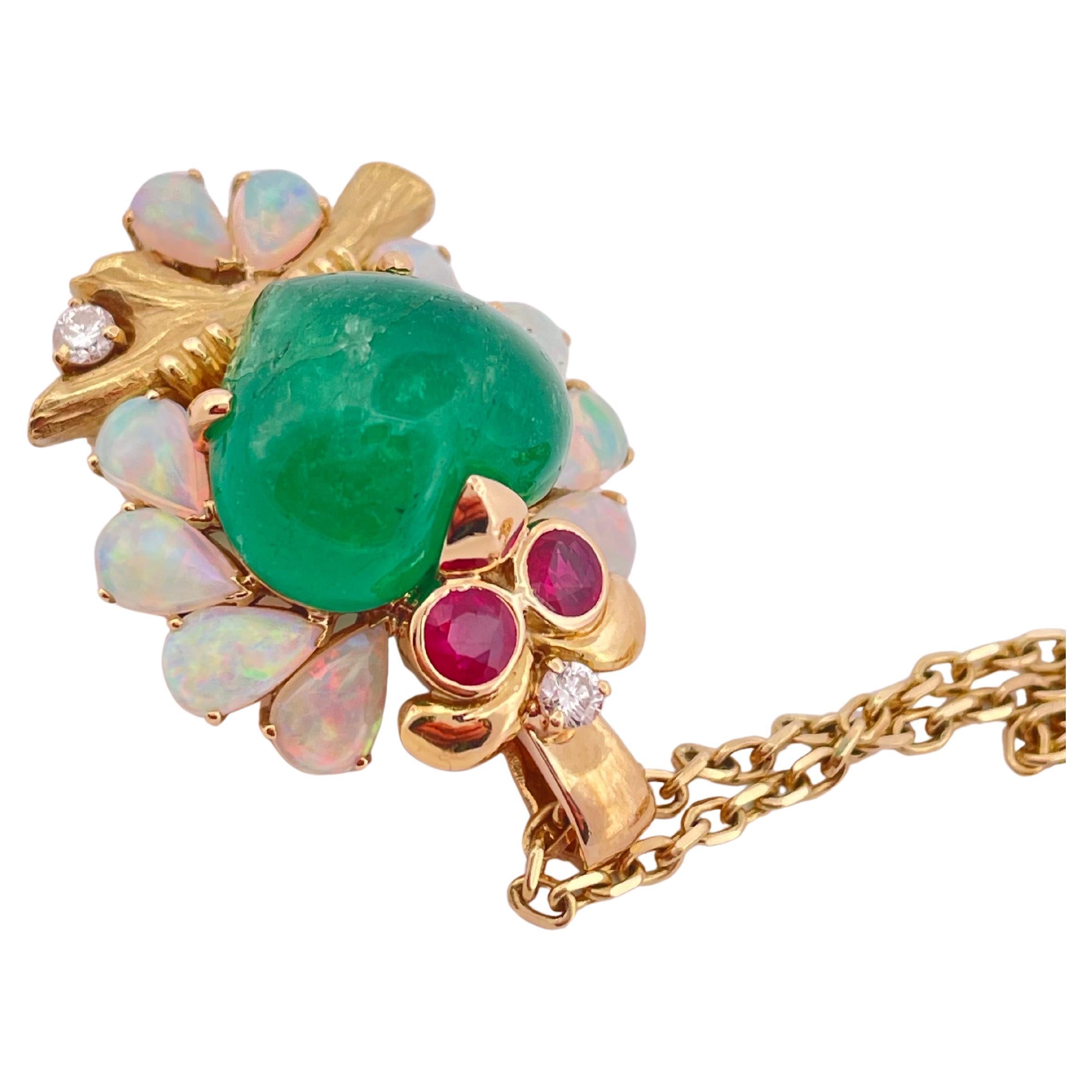 Whimsical and luxurious, this charming owl pendant is a celebration of vibrant gemstones and fine craftsmanship. Crafted in 18k yellow gold, the owl’s body features a striking cabochon emerald, radiating deep green brilliance. A crown of pear-shaped
