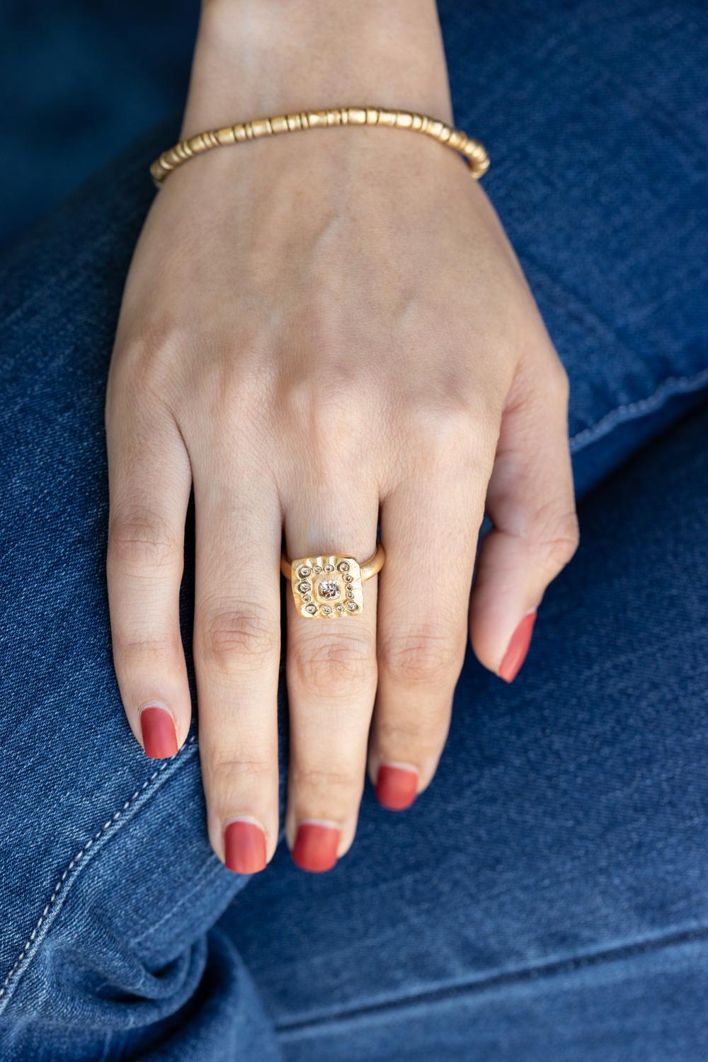 Unveil the allure of timeless elegance with this exquisite 18K Yellow Gold Ring by Audrius Krulis, featuring a stunning round brown diamond as its centerpiece. The 0.81-carat brown diamond exudes a warm, earthy brilliance, captivating with its rich