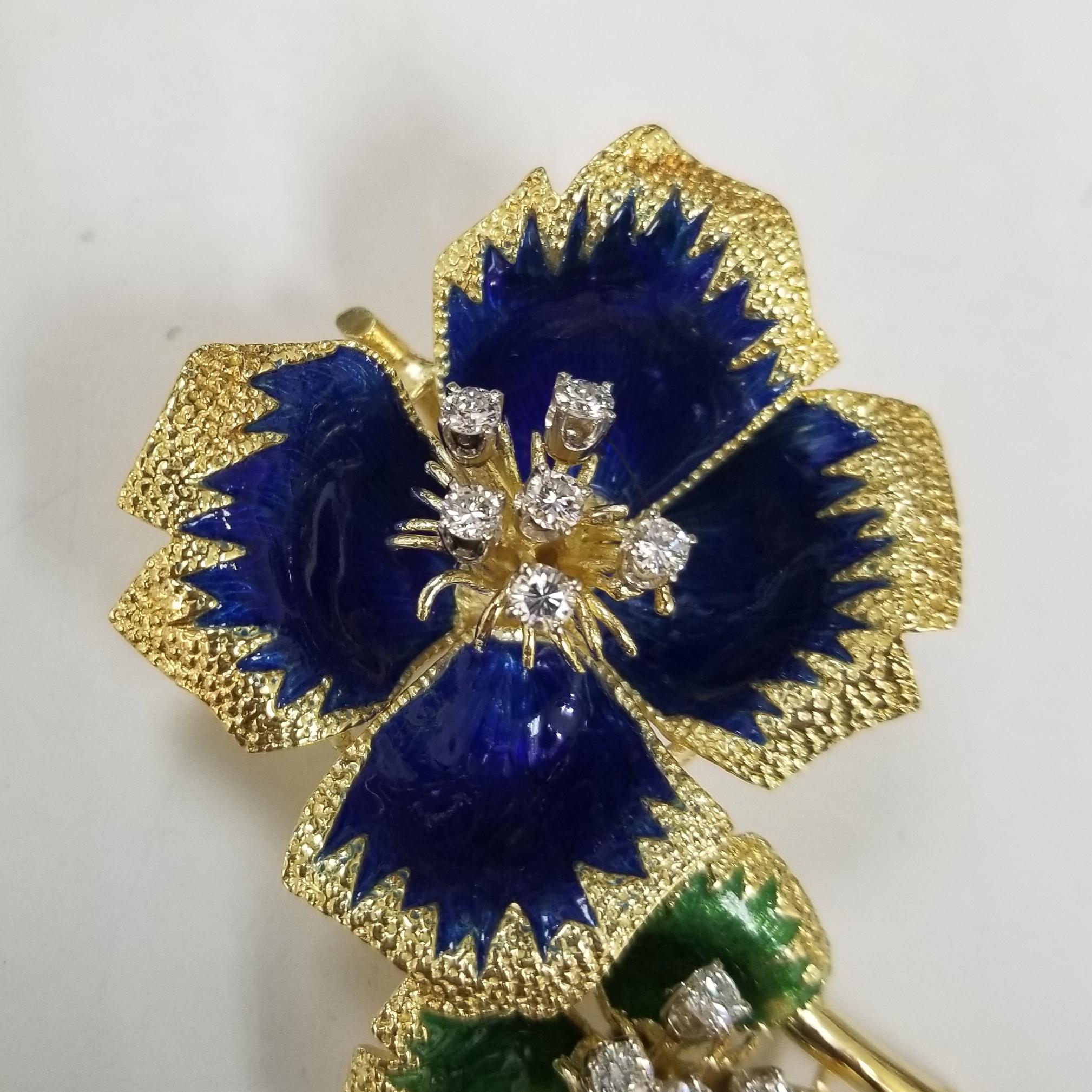 Cette broche unique en son genre, en or jaune 18 carats avec des fleurs en émail bleu et vert, est un ajout indispensable à votre boîte à bijoux. Cadeau idéal pour un être cher, cette superbe broche a été délicatement émaillée à la main d'un bleu et
