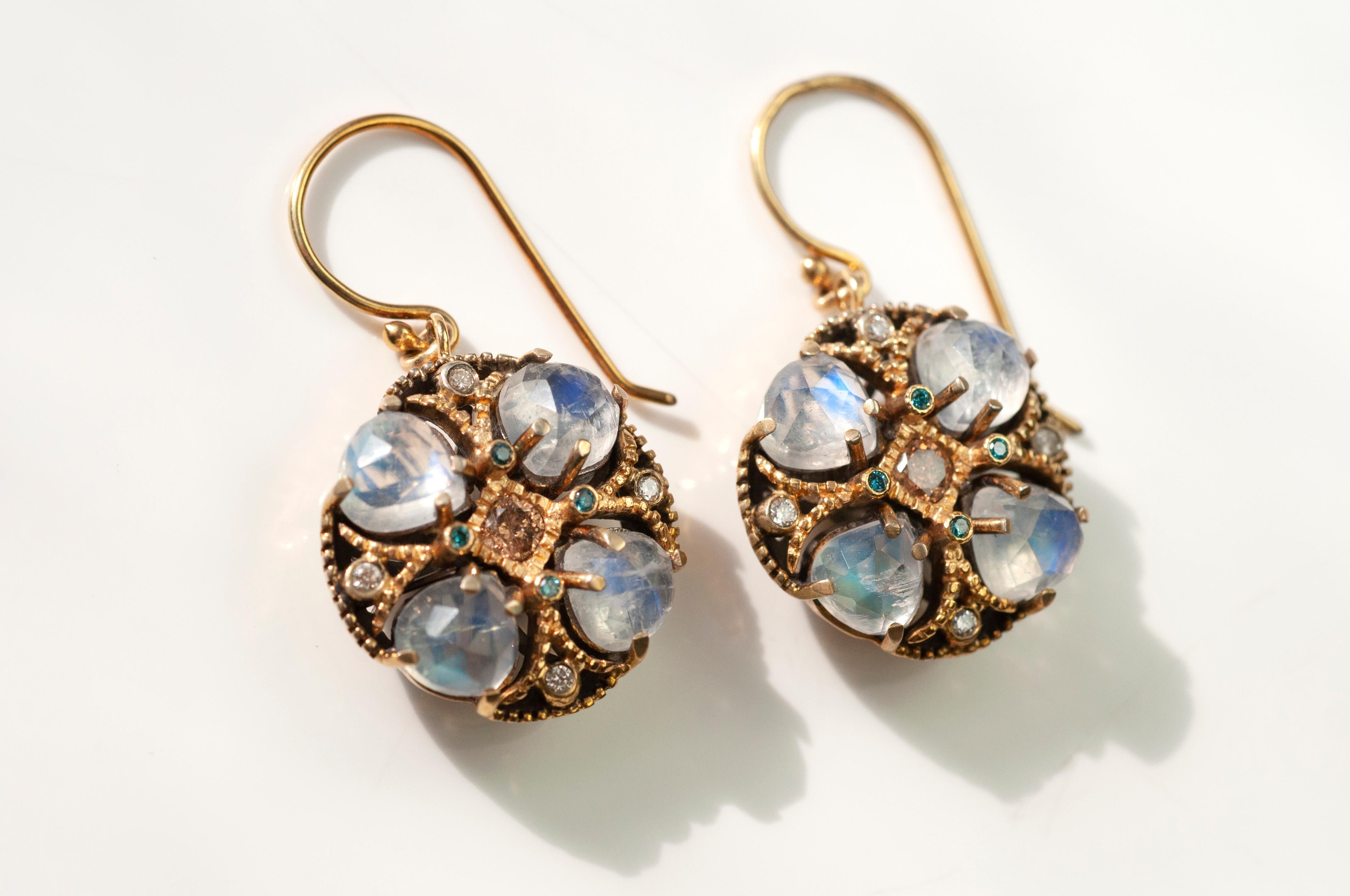 These floral Poppy earrings feature rainbow moonstones 6.00cts and teal and white diamonds 0.58cts with 18K yellow gold and blackened sterling silver gallery detail on the back. They hang at about 1.28inches from 18 K yellow gold ear wire.

Like